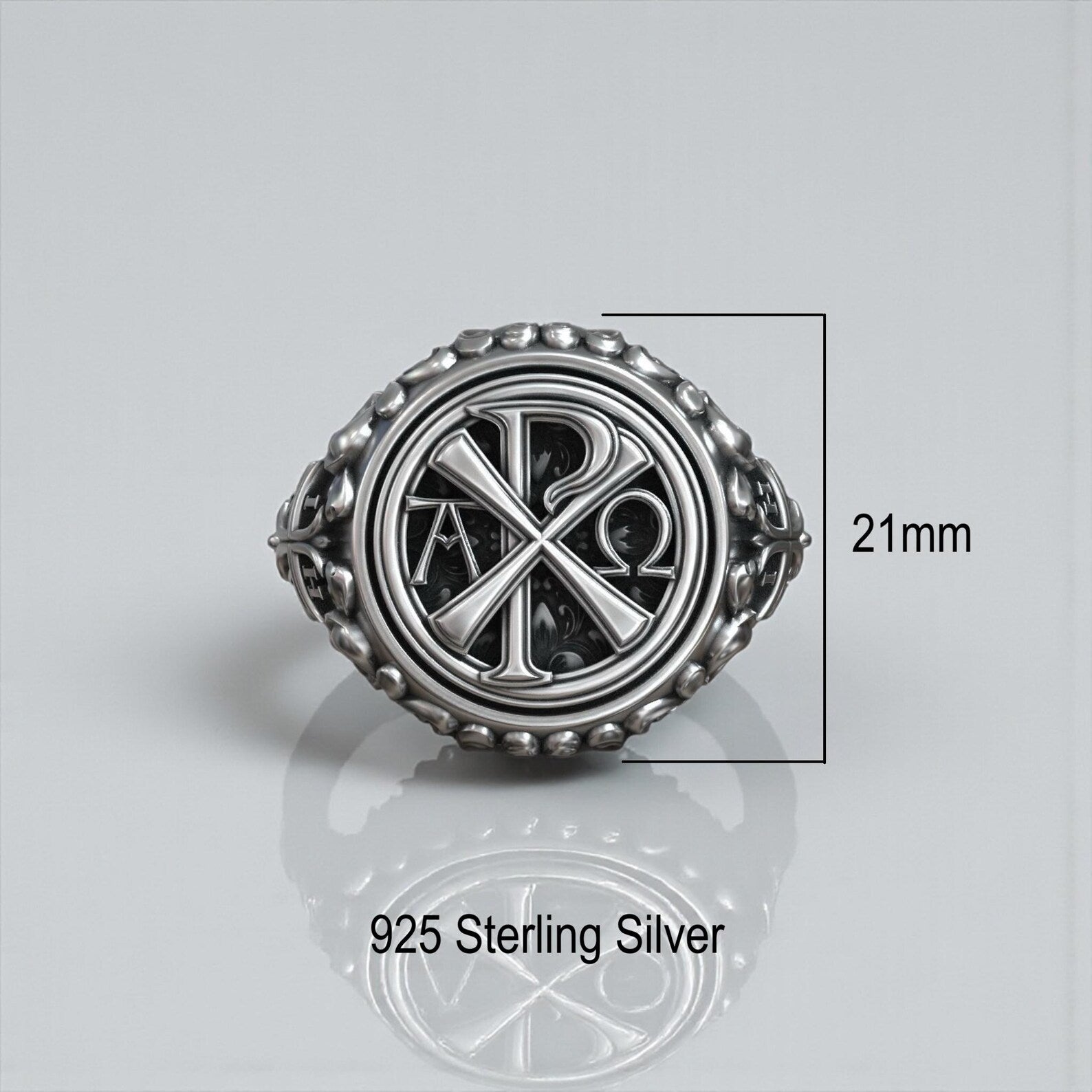 Close-up macro of a Chi Rho Alpha Omega ring highlighting detailed sacred engravings, oxidized texture and handcrafted sterling silver religious craftsmanship