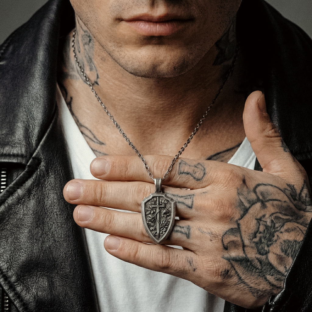 Vintage style gothic warrior necklace for men featuring floral engraved shield and sword design solid silver handcrafted statement jewelry with oxidized contrast