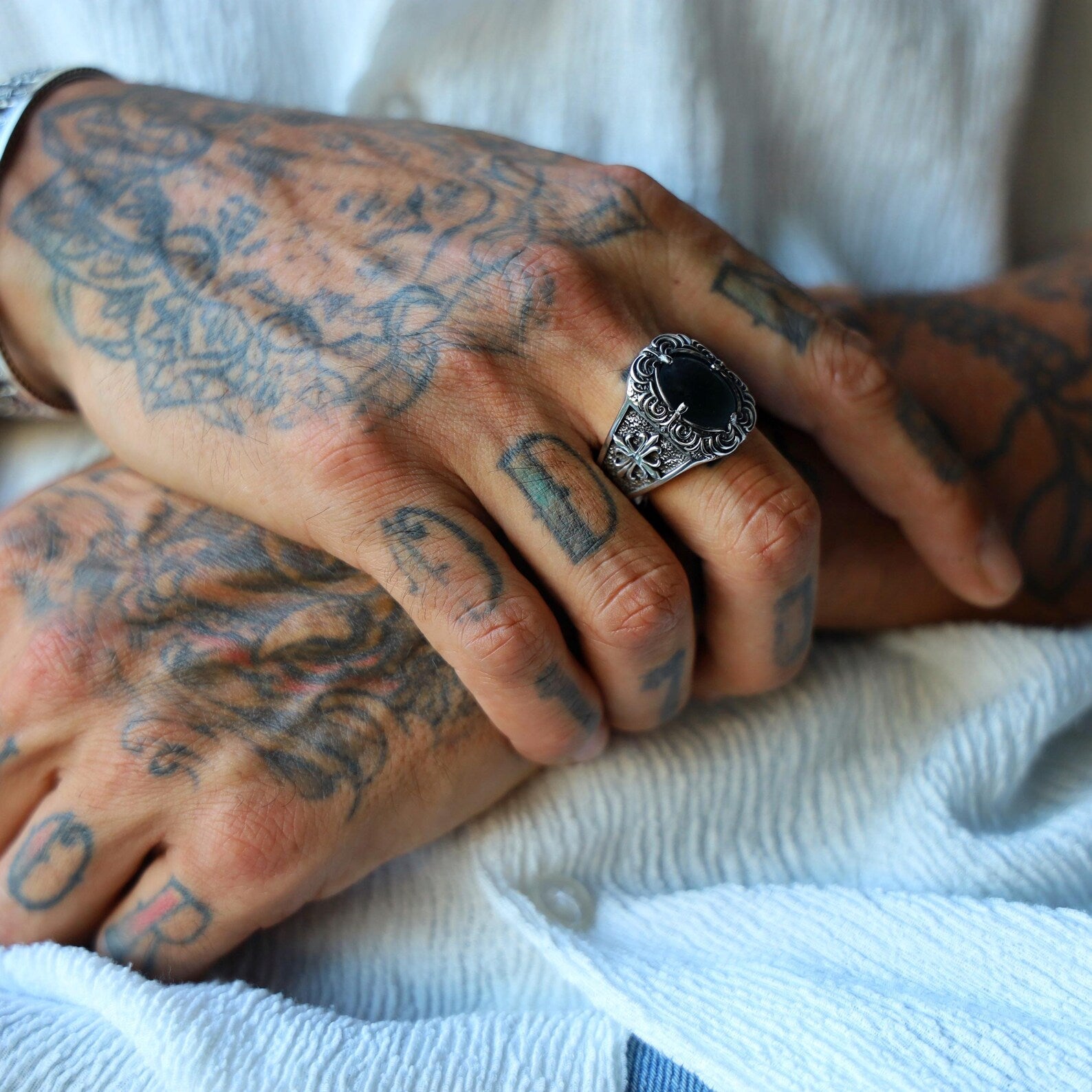 Close-up view of a handcrafted gothic onyx ring for men, featuring a deep black gemstone set in solid sterling silver with bold biker-style details, ideal for those who embrace edgy fashion and statement accessories.