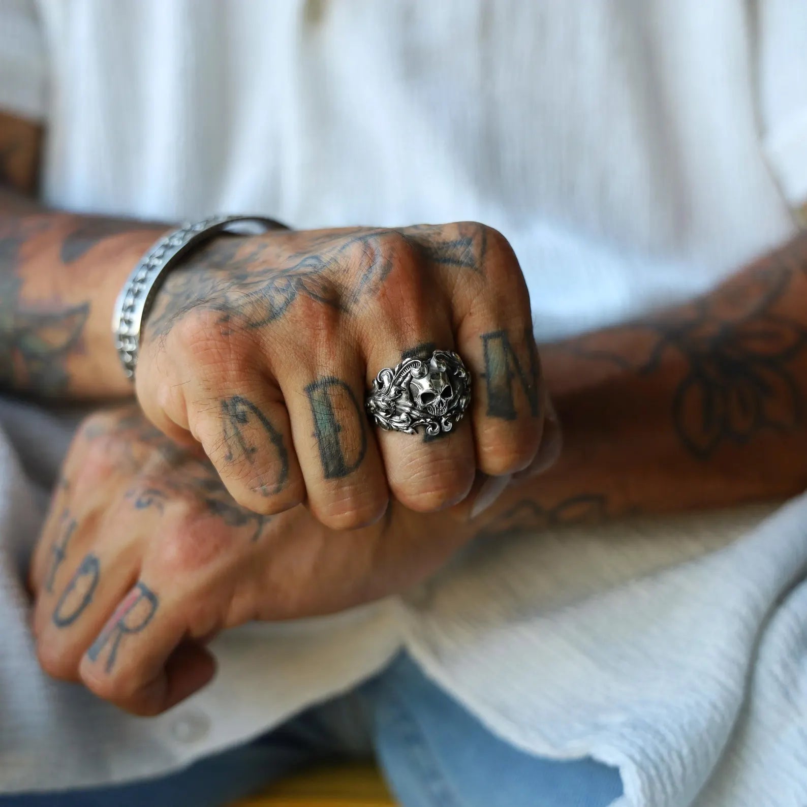 Close-up image of a handcrafted sterling silver gothic skull ring for men, featuring intricate baroque-style detailing around the skull and band, designed with a bold biker aesthetic and antique silver finish.
