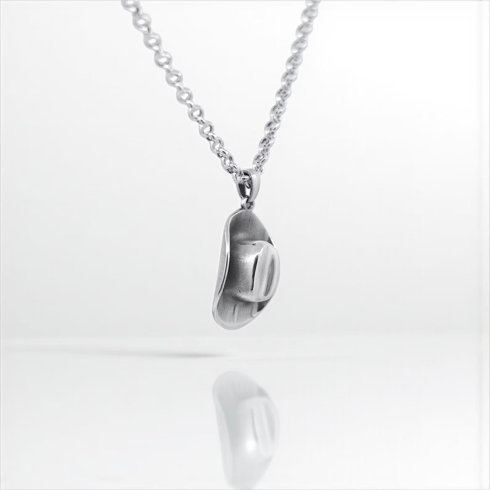 Rustic western-style necklace with a miniature cowboy hat pendant, made from solid sterling silver, designed to capture the spirit of country life and cowboy culture, ideal for men or women.