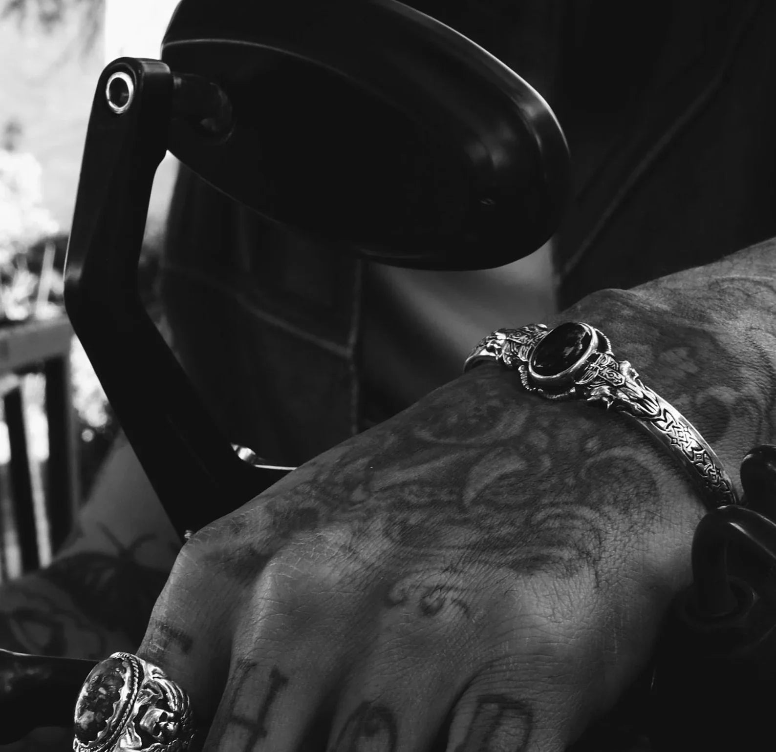 Close-up view of a men’s silver biker bracelet with a striking onyx centerpiece and engraved gothic patterns. The handcrafted detailing and high-polish finish make this adjustable cuff bracelet a meaningful and masculine accessory for modern-day warriors and jewelry lovers alike.