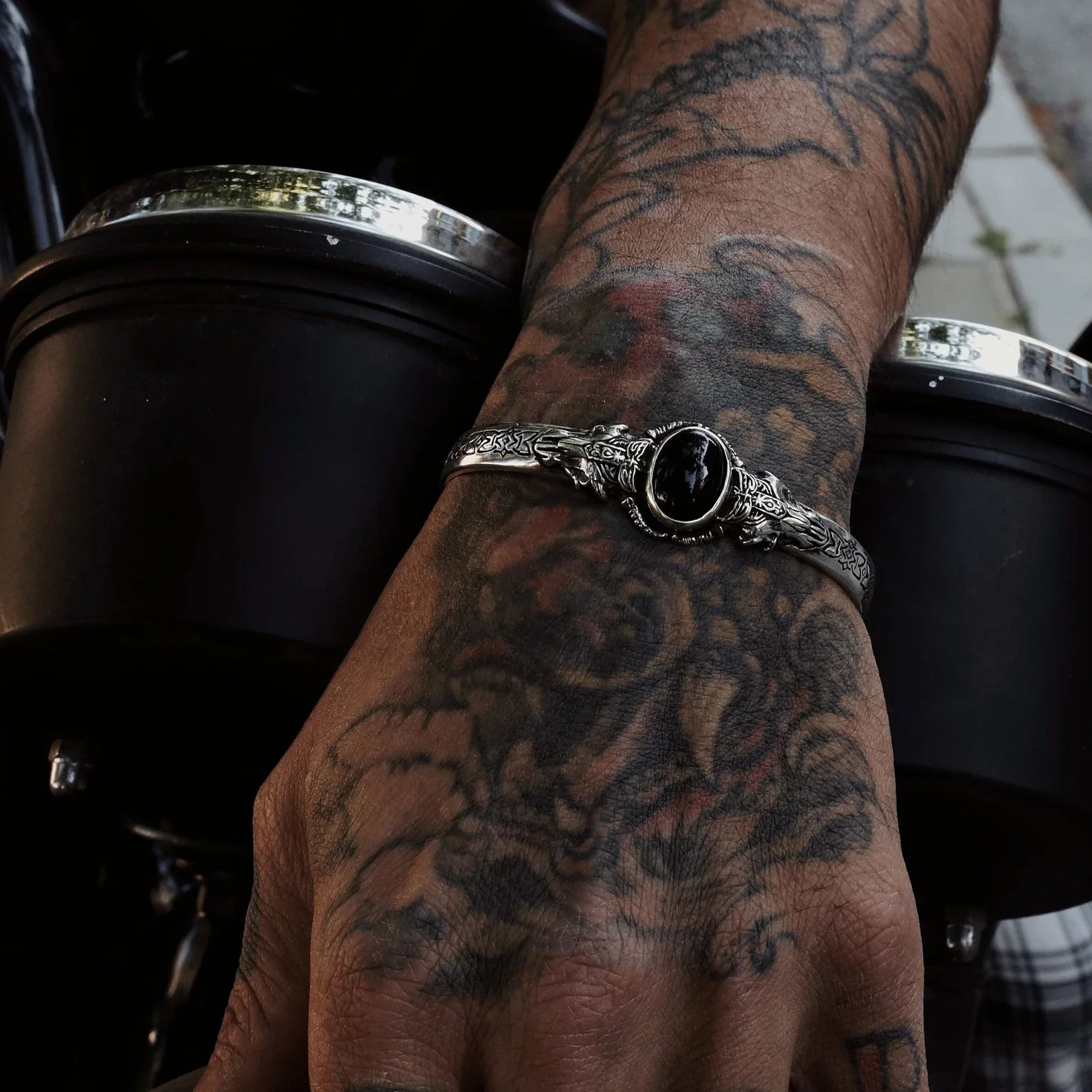Handcrafted sterling silver cuff bracelet featuring a bold black onyx stone at its center. This Viking-inspired silver bangle showcases intricate engraved patterns and symbolizes power, mystery, and inner strength—making it the perfect fantasy statement bracelet for men who embrace bold, meaningful jewelry.