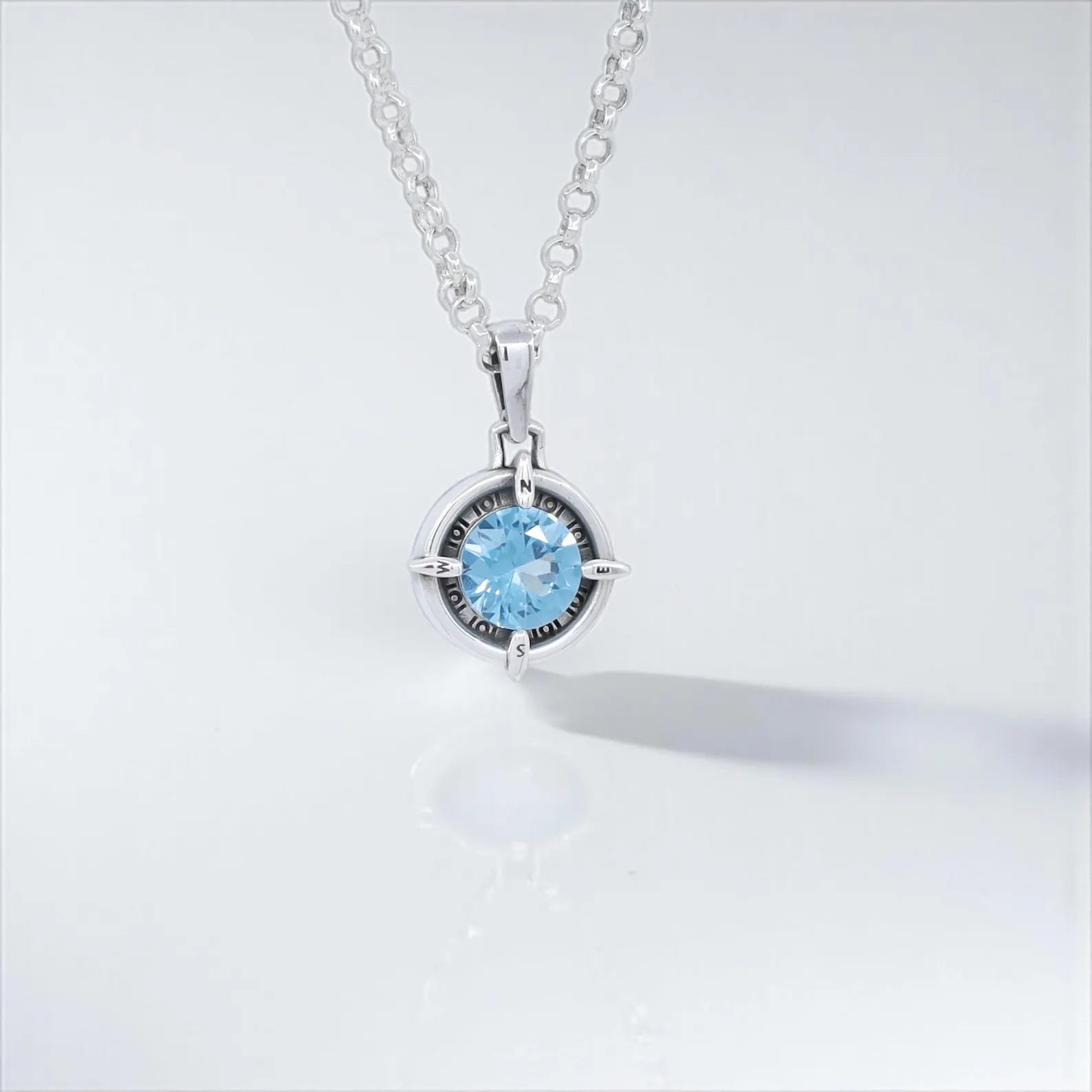 Handmade sterling silver compass pendant necklace featuring a sparkling aquamarine birthstone. This nautical jewelry piece is perfect for travelers, sailors, and adventurers. A meaningful March birthstone gift for men and women who love the ocean, adventure, and unique handmade jewelry. Ideal birthday, anniversary, or Christmas gift.