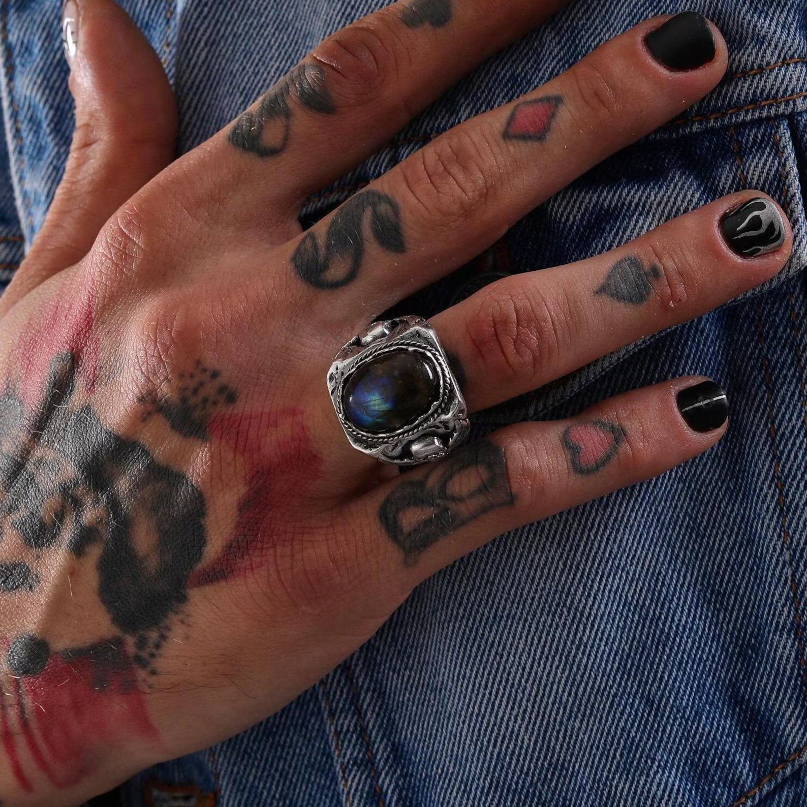 A stunning silver biker ring with an iridescent labradorite centerpiece and finely sculpted skull wings, symbolizing transformation, protection, and rebellious strength. This handcrafted statement piece is ideal for gifting to a man with bold fashion taste and a love for gothic symbolism.