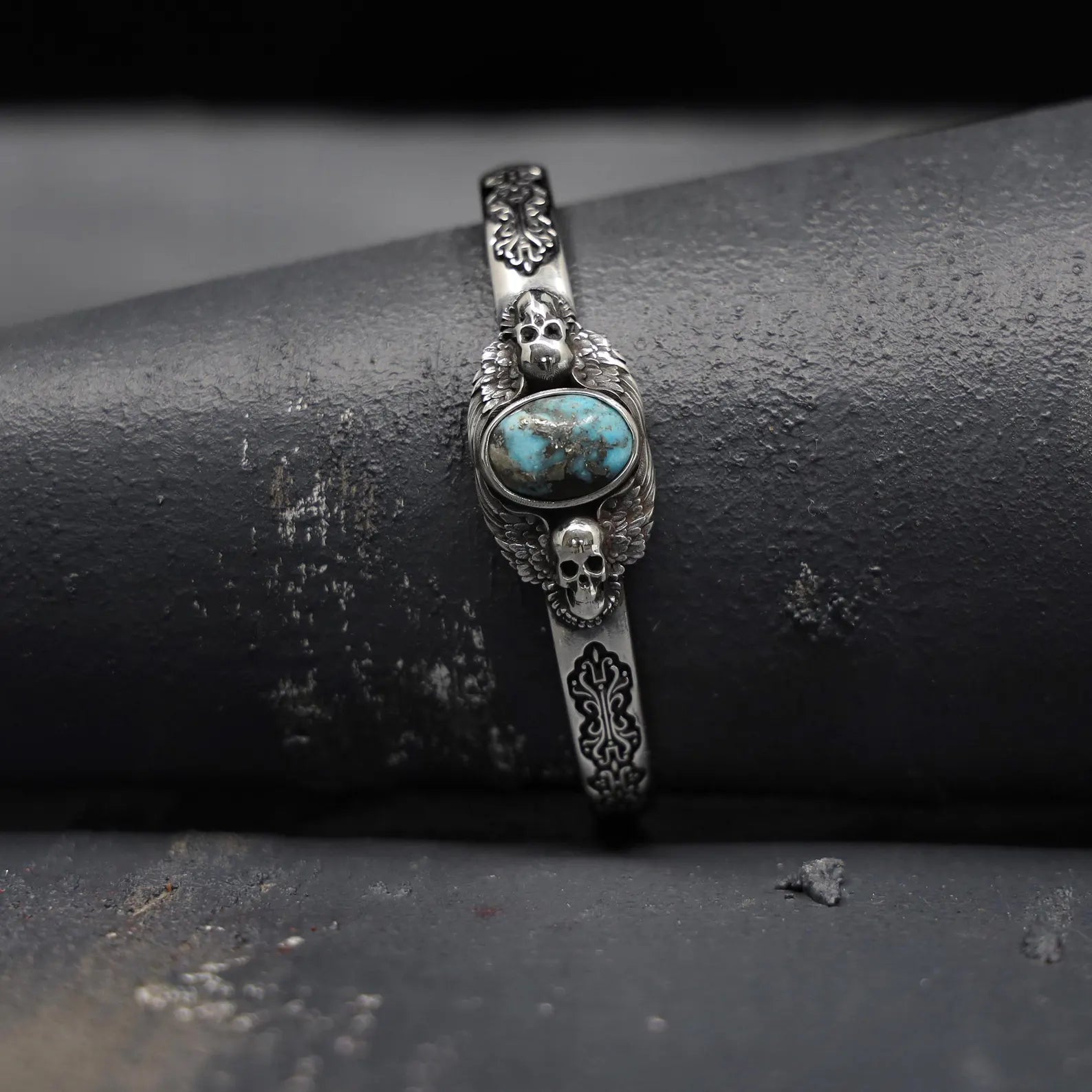 Unique angle capturing the gothic elegance and spiritual power of this men’s turquoise stone silver cuff bracelet. With a detailed skull motif and vibrant turquoise gemstone, this handcrafted bracelet embodies the rugged yet refined style of modern biker jewelry. It’s a striking accessory that celebrates individuality and personal strength.