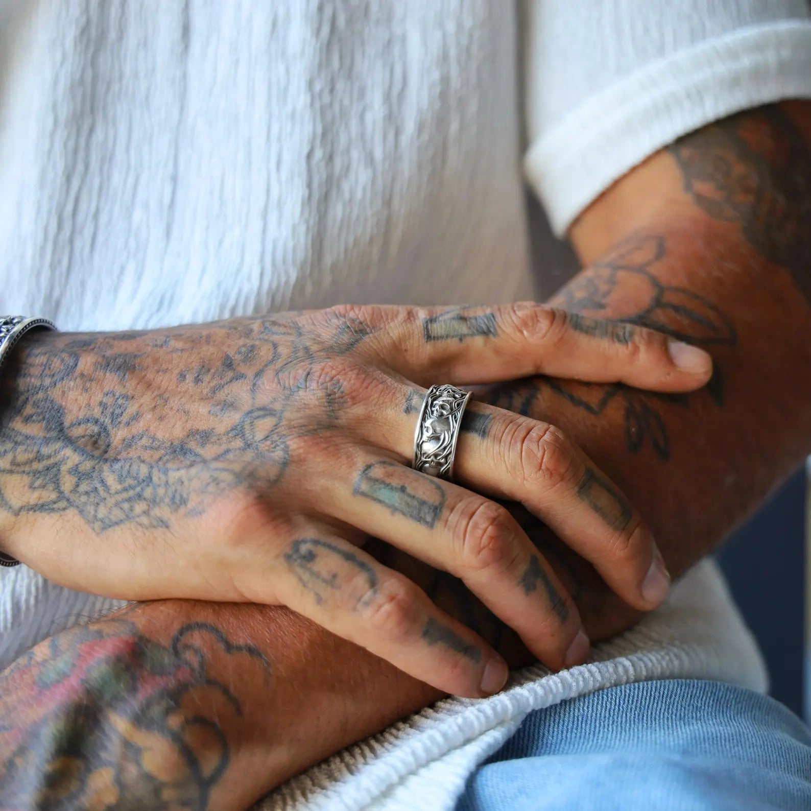Close-up view of a wide sterling silver band ring with detailed skull engravings, designed for men who appreciate gothic and biker fashion. Handmade with oxidized finish to highlight every sculpted detail, this ring delivers both durability and symbolism. A powerful accessory representing rebellion, mortality, and strength.