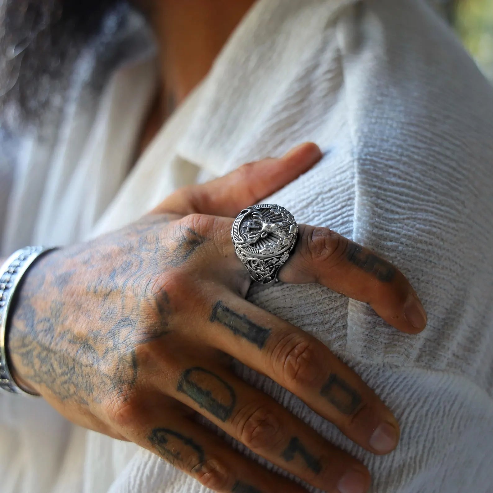 Close-up image of a handcrafted sterling silver deer ring for men, featuring an intricately carved stag head surrounded by gothic-style forest leaves, symbolizing strength, nature, and timeless masculine elegance.