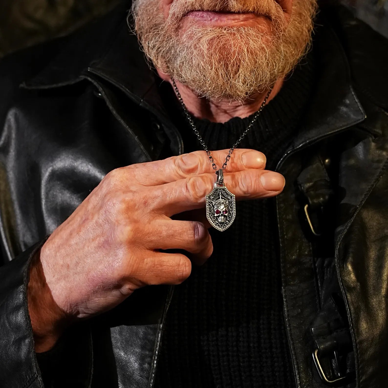 Double-sided gothic pendant necklace in high-quality sterling silver, showcasing a bold skull with a crown and red eyes, and a beautifully engraved sword on the reverse. This shield-style pendant is ideal for lovers of warrior-inspired accessories, biker fashion, and personalized gothic statement pieces.