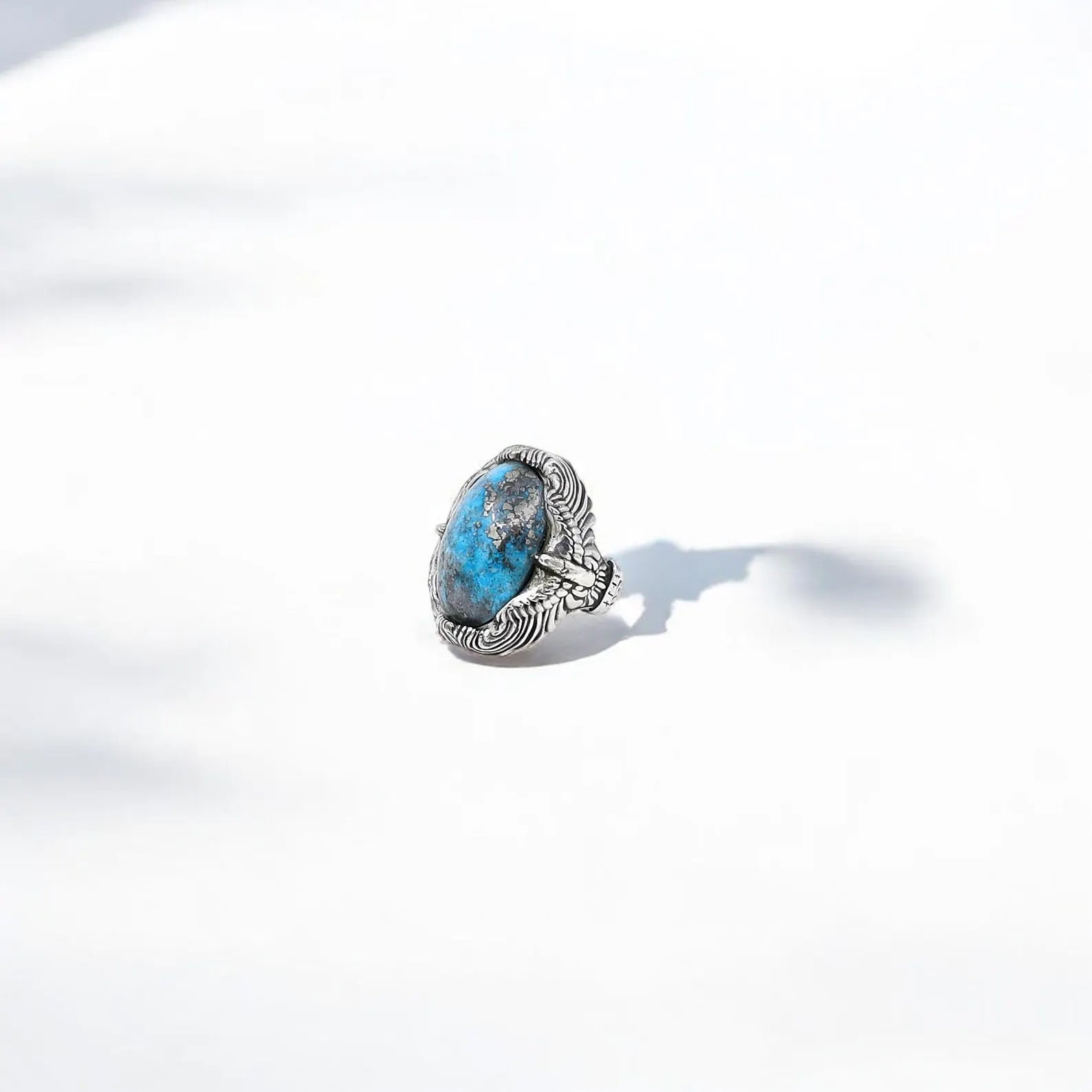 This Native American inspired turquoise ring is handcrafted from high-quality sterling silver and features a richly textured surface with flowing, organic patterns. The bright blue gemstone offers contrast and meaning, believed to bring peace, clarity, and emotional strength to the wearer. Ideal for daily use or special occasions.