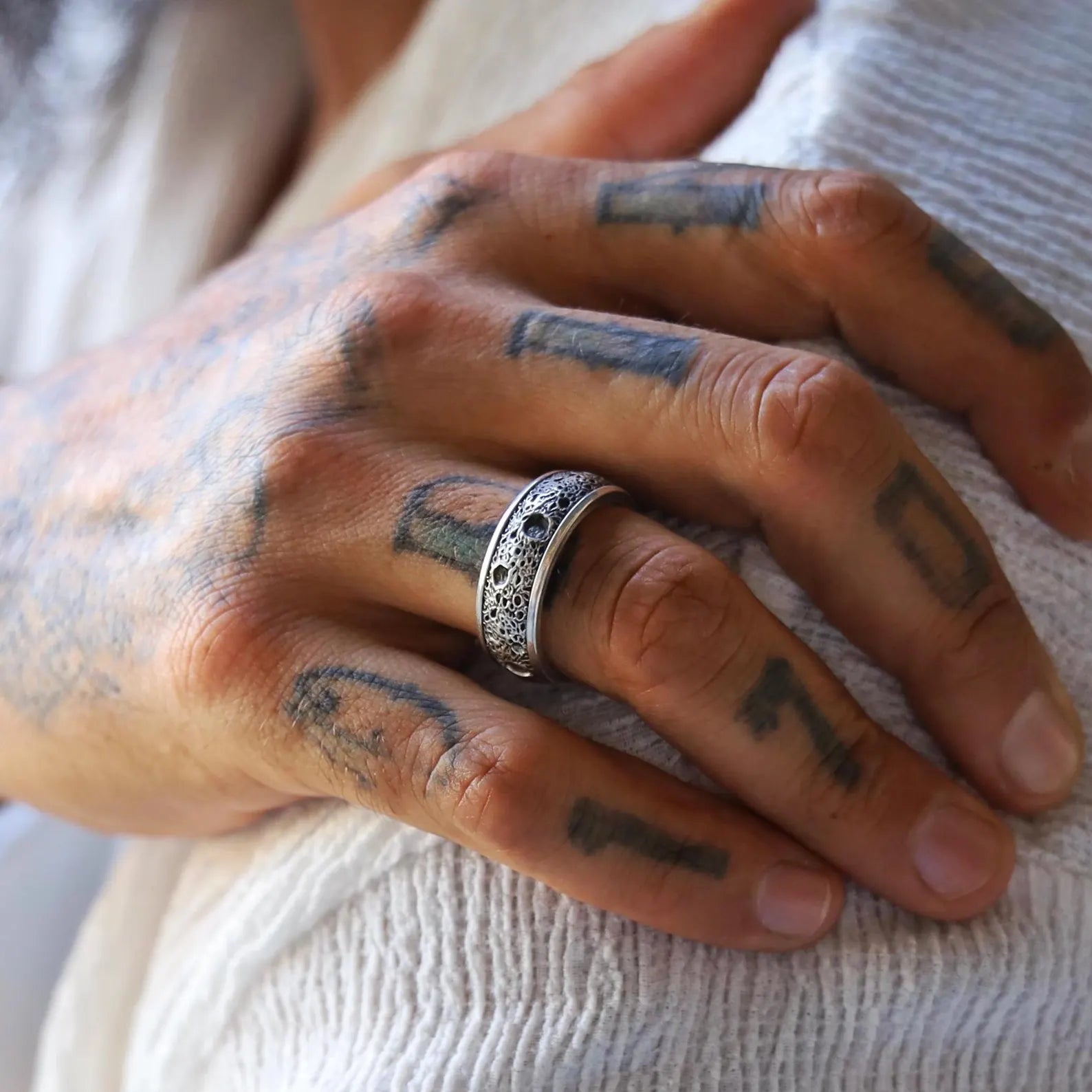 Close-up image of a textured sterling silver band ring for men, featuring a vintage-style matte finish with subtle gothic influence, handcrafted to offer a minimalist yet bold statement for everyday wear.