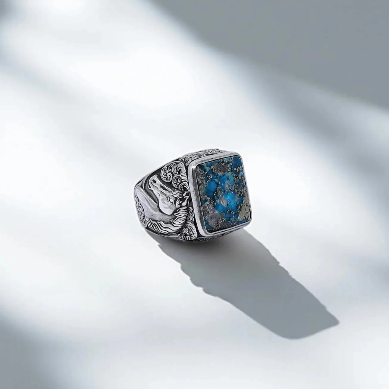 Handcrafted sterling silver men's ring featuring a square-cut natural turquoise gemstone and an intricately engraved horse design on the band – perfect for western and cowboy style lovers.