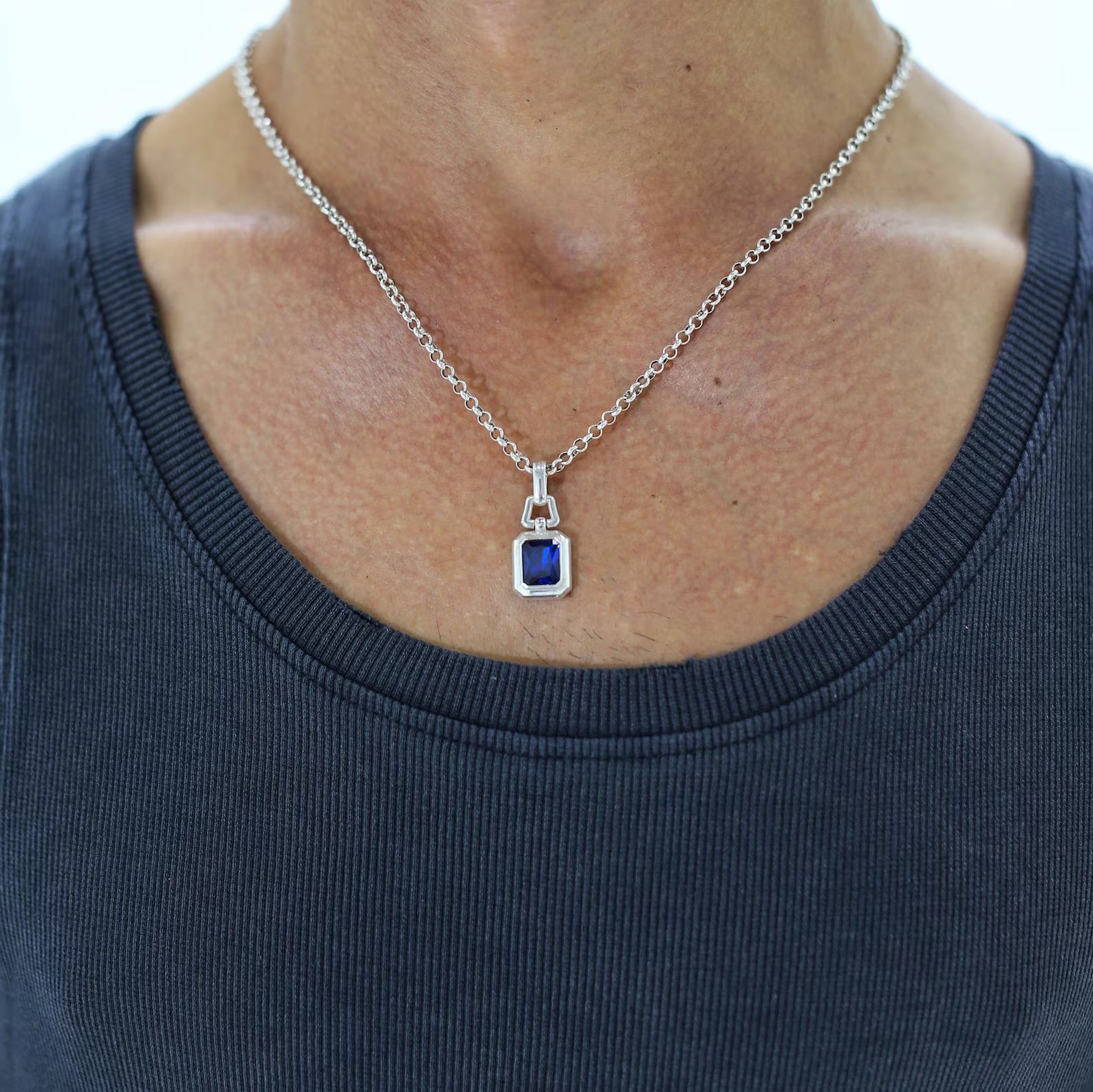 A bold and polished 925 silver necklace designed with a deep blue emerald-cut sapphire stone, offering a refined and masculine look for men who appreciate elegant simplicity. Perfect for birthdays, anniversaries, or as a luxurious September birthstone gift.
