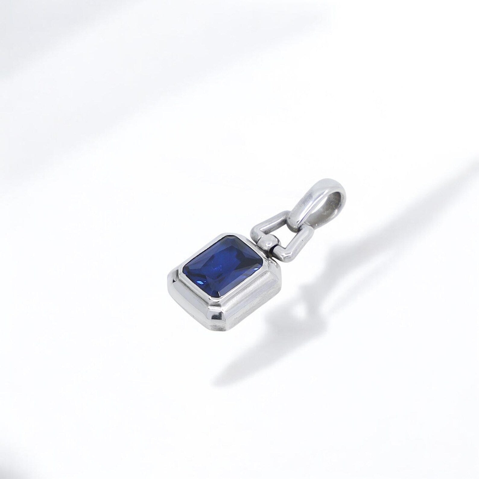 A minimalist men’s silver necklace featuring a striking blue sapphire stone set in a rectangular frame, handcrafted for comfort and elegance. With its polished finish and meaningful gemstone, this necklace makes a perfect gift for a boyfriend, husband, son, or father.