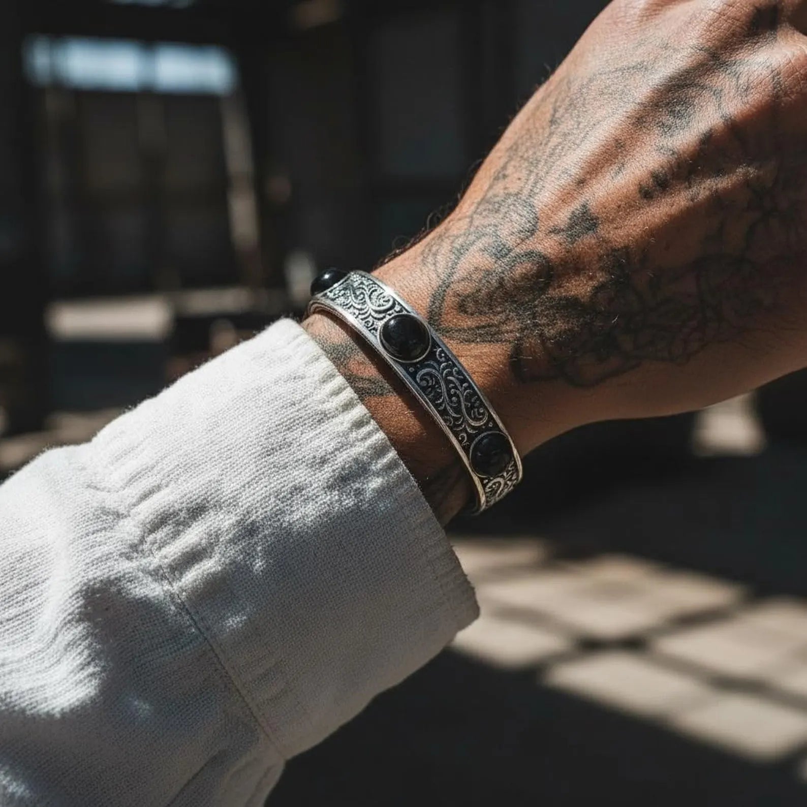 Close-up of chunky sterling silver onyx cuff bracelet with handcrafted oxidized finish, showcasing three natural onyx gemstones set in an engraved biker-style design, perfect for gifting on birthdays or anniversaries.