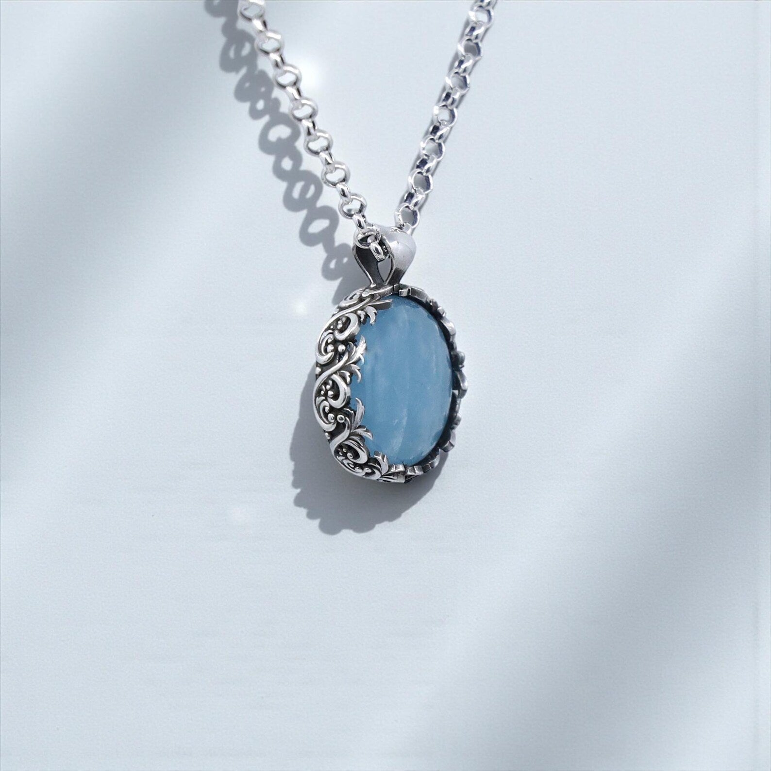Elegant aquamarine birthstone necklace in a handcrafted sterling silver floral design, featuring a large round blue gemstone with soothing energy, ideal for birthdays, anniversaries, Christmas gifts, and meaningful personalized jewelry.