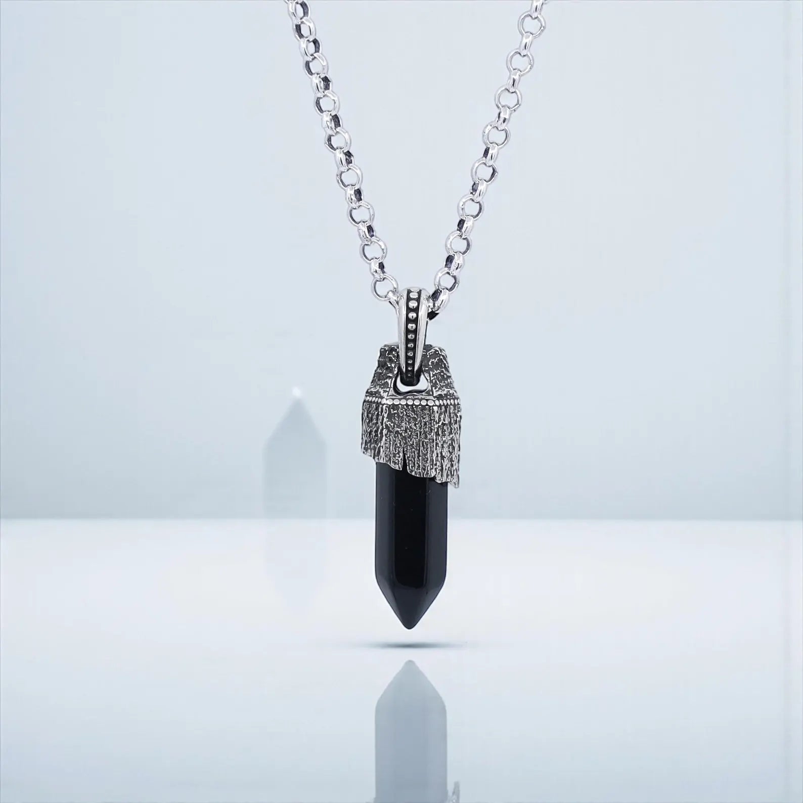 Artistic shot of a black obsidian gemstone pendant crafted in 925 sterling silver, featuring a compass motif and oxidized details, designed as a spiritual grounding necklace for men who love vintage-inspired and meaningful jewelry.