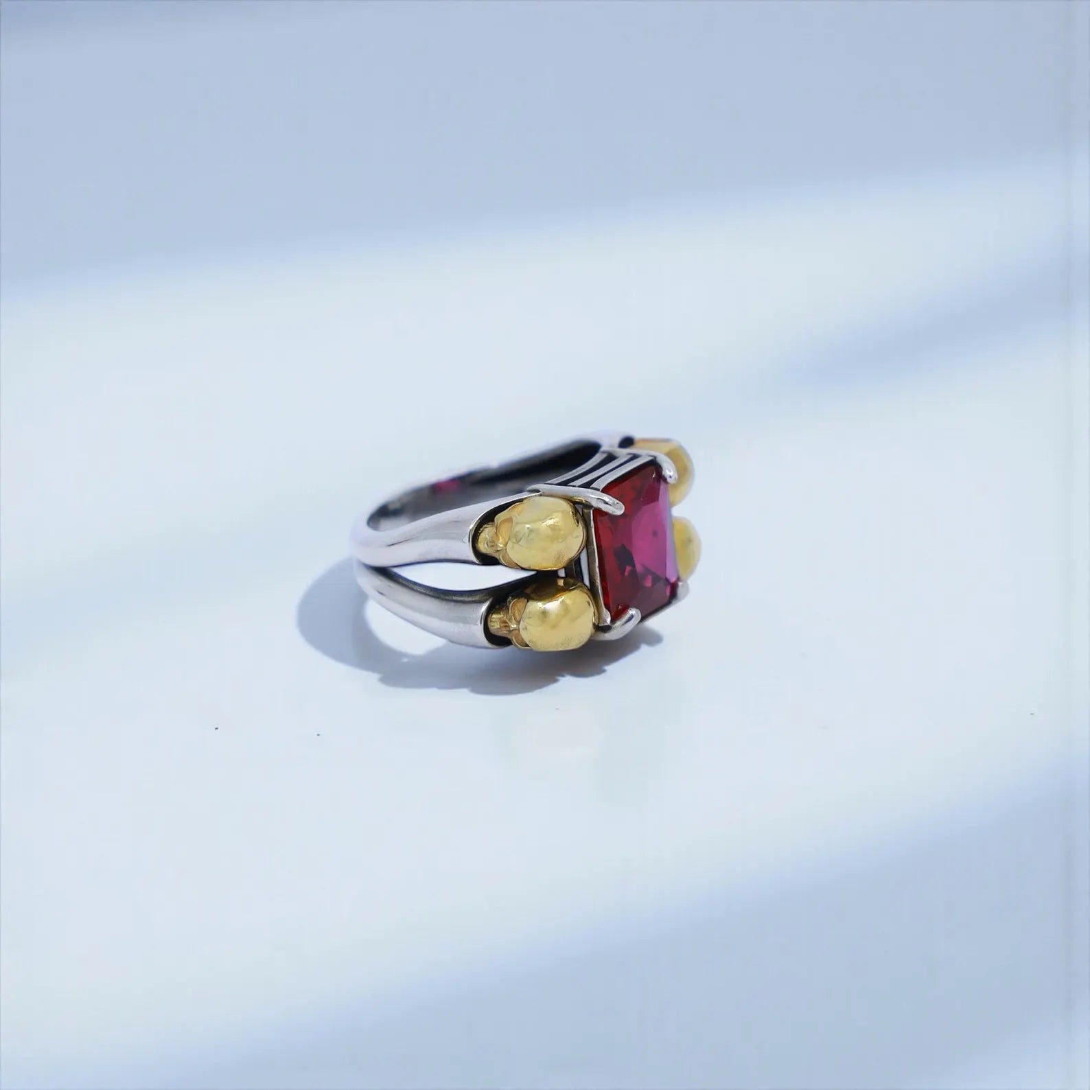 High-detail close-up of a handcrafted emerald gothic skull ring, showcasing the oxidized sterling silver texture, bold masculine edges, and the luminous emerald-cut gemstone—optimized for gothic skull jewelry, emerald mens ring, and luxury biker accessories.