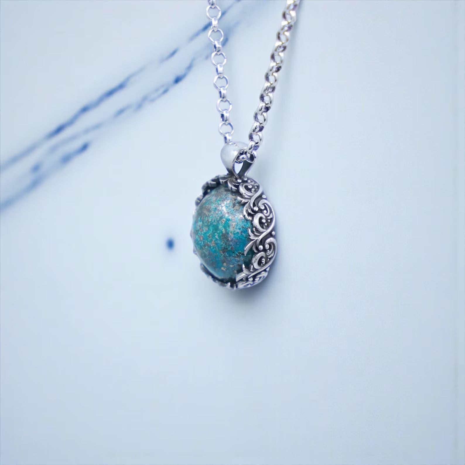 High-quality turquoise men’s necklace crafted from premium 925 sterling silver, featuring a vintage round baroque pendant with detailed leaf engravings surrounding a natural turquoise stone; perfect for men who appreciate bold, meaningful, and timeless gemstone jewelry pieces with artisan craftsmanship