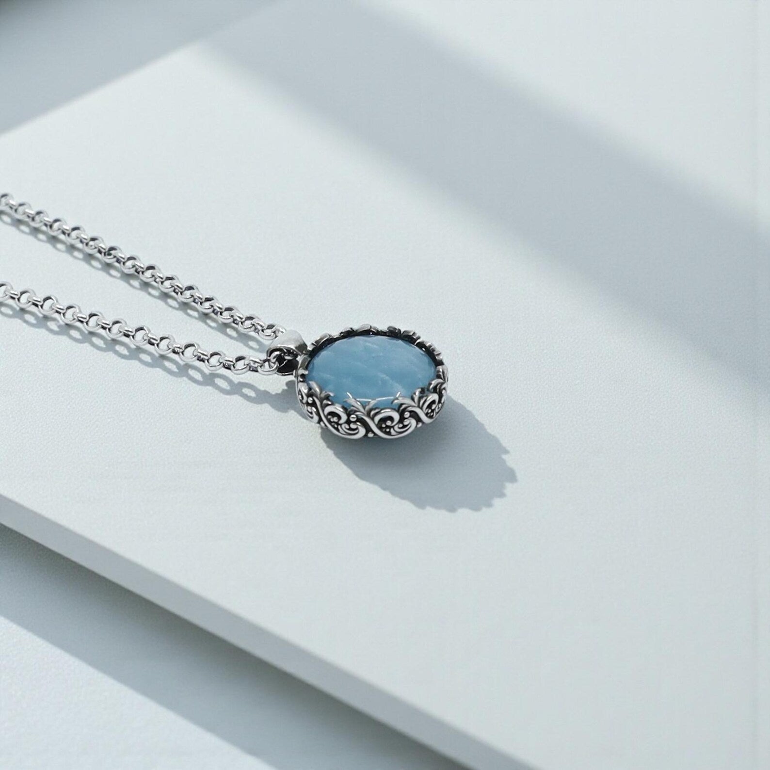 Artisan-made aquamarine pendant necklace with a 20mm natural gemstone set in a silver floral baroque bezel, symbolizing clarity and emotional balance, crafted for jewelry lovers who appreciate high-quality handmade pieces.