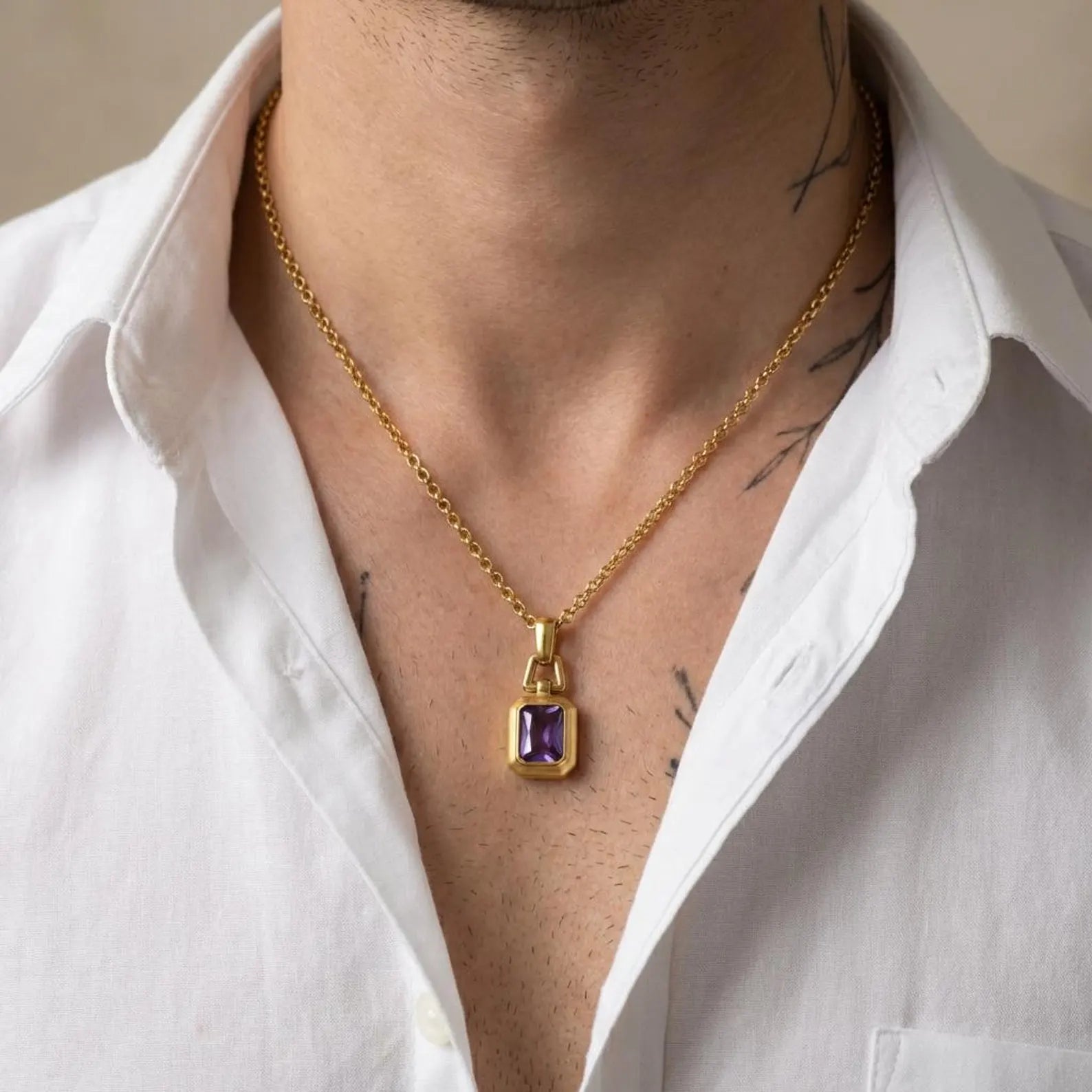 Close-up view of a handcrafted amethyst birthstone pendant necklace with 18k gold plating over sterling silver, highlighting the polished geometric pendant design and deep purple gemstone clarity