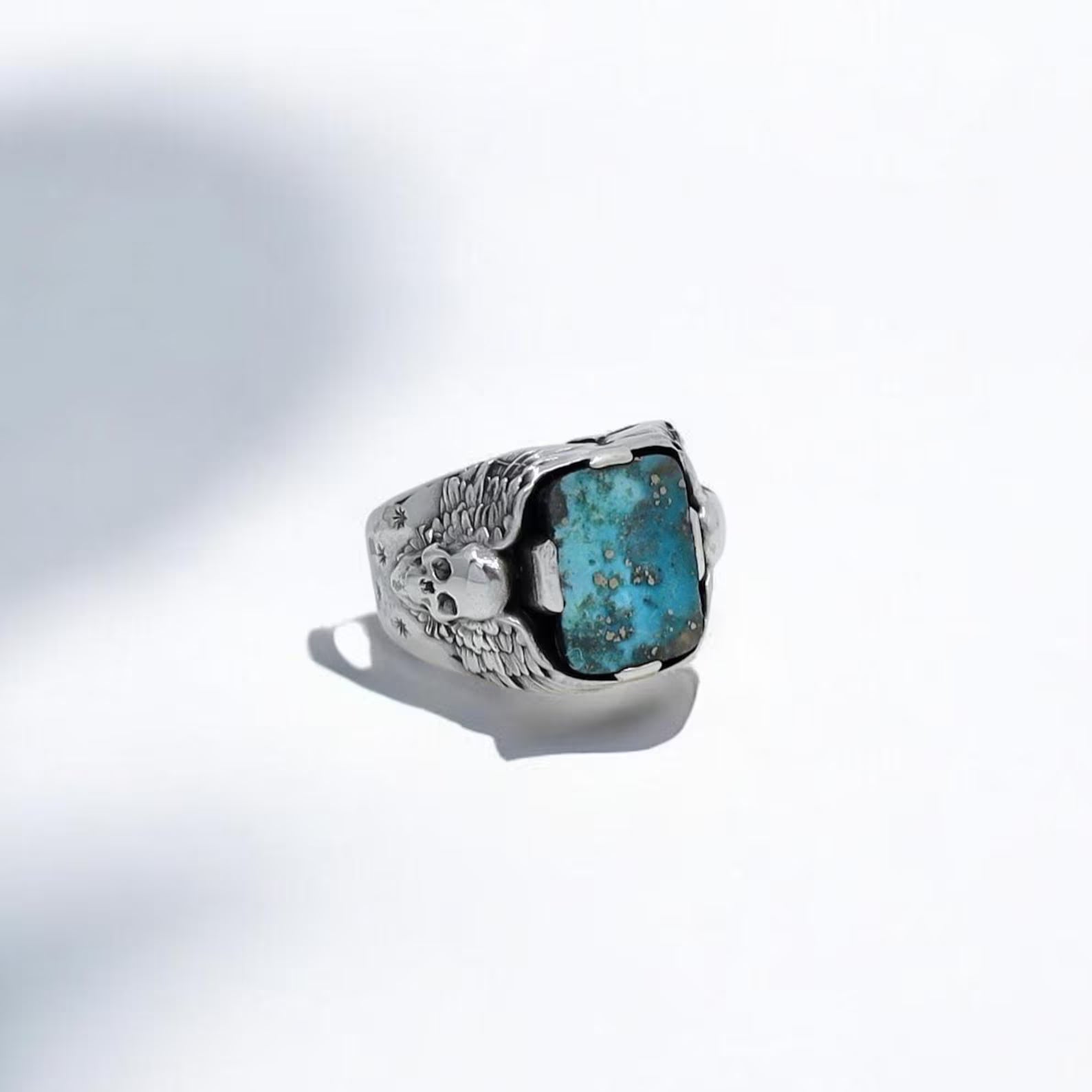 Experience the power and symbolism of this handcrafted sterling silver skull ring, showcasing a raw-cut turquoise gemstone at its center. The double skull design evokes gothic and motorcycle-inspired energy, making it a bold accessory for men who live freely and ride hard. With its rustic antique finish and striking blue stone, this turquoise skull ring is a meaningful gift for boyfriends, husbands, or fathers who embrace biker lifestyle.