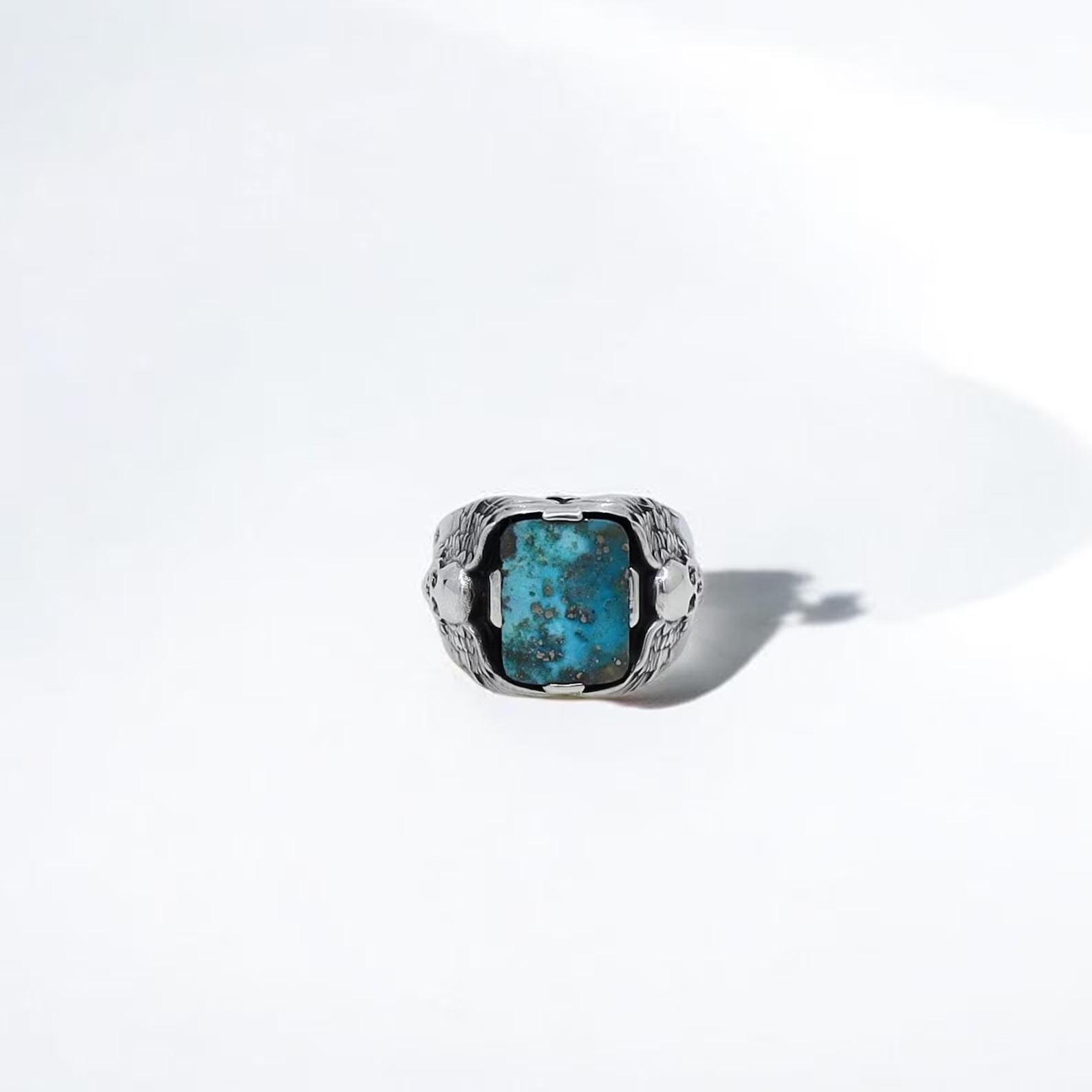Showcasing a vintage gothic look, this men’s turquoise ring features twin skulls carved into high-quality sterling silver. The rich blue turquoise stone adds a natural contrast and symbolizes wisdom, strength, and protection. This ring is a must-have piece for gothic jewelry collectors, Harley Davidson fans, and anyone searching for a handcrafted, one-of-a-kind biker gift for him.