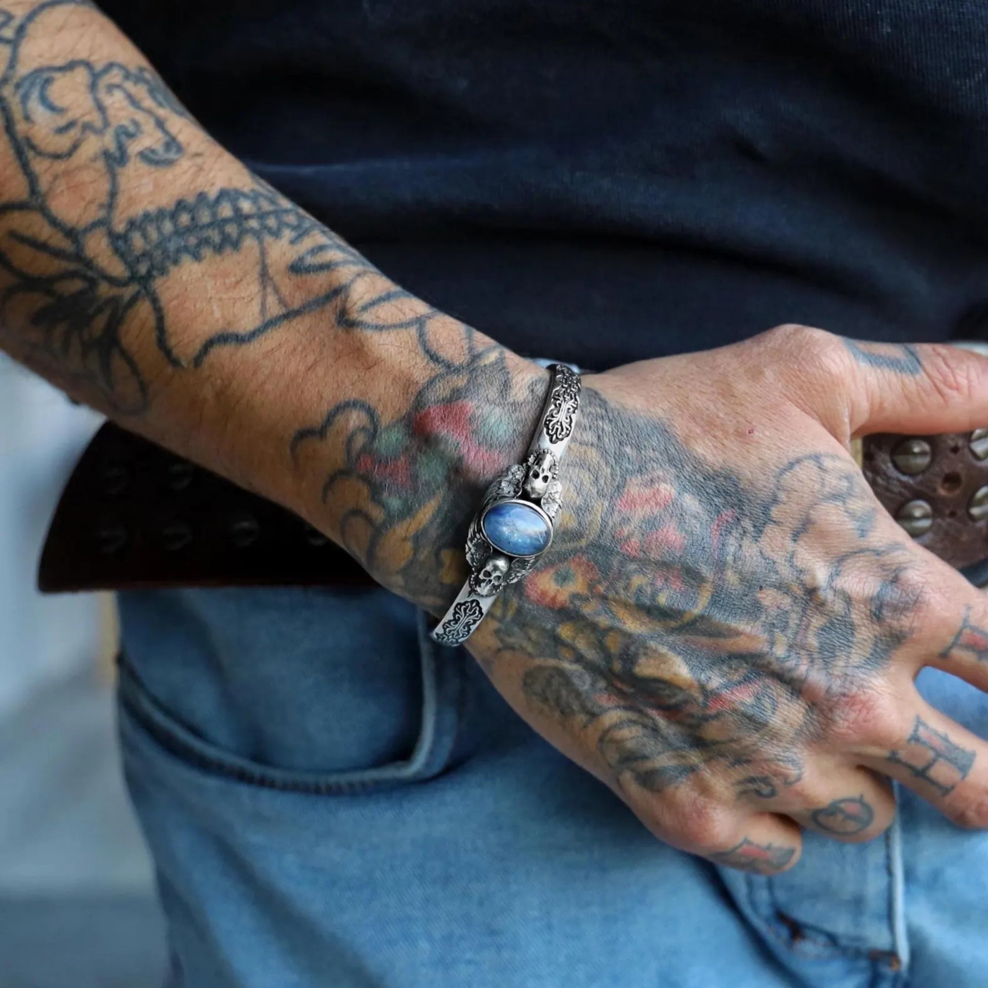 Elegant handcrafted blue kyanite silver cuff bracelet with skull and feather detailing. Made from solid 925 sterling silver, this adjustable men’s bracelet captures gothic artistry and masculine power, designed for lovers of unique handmade silver jewelry.