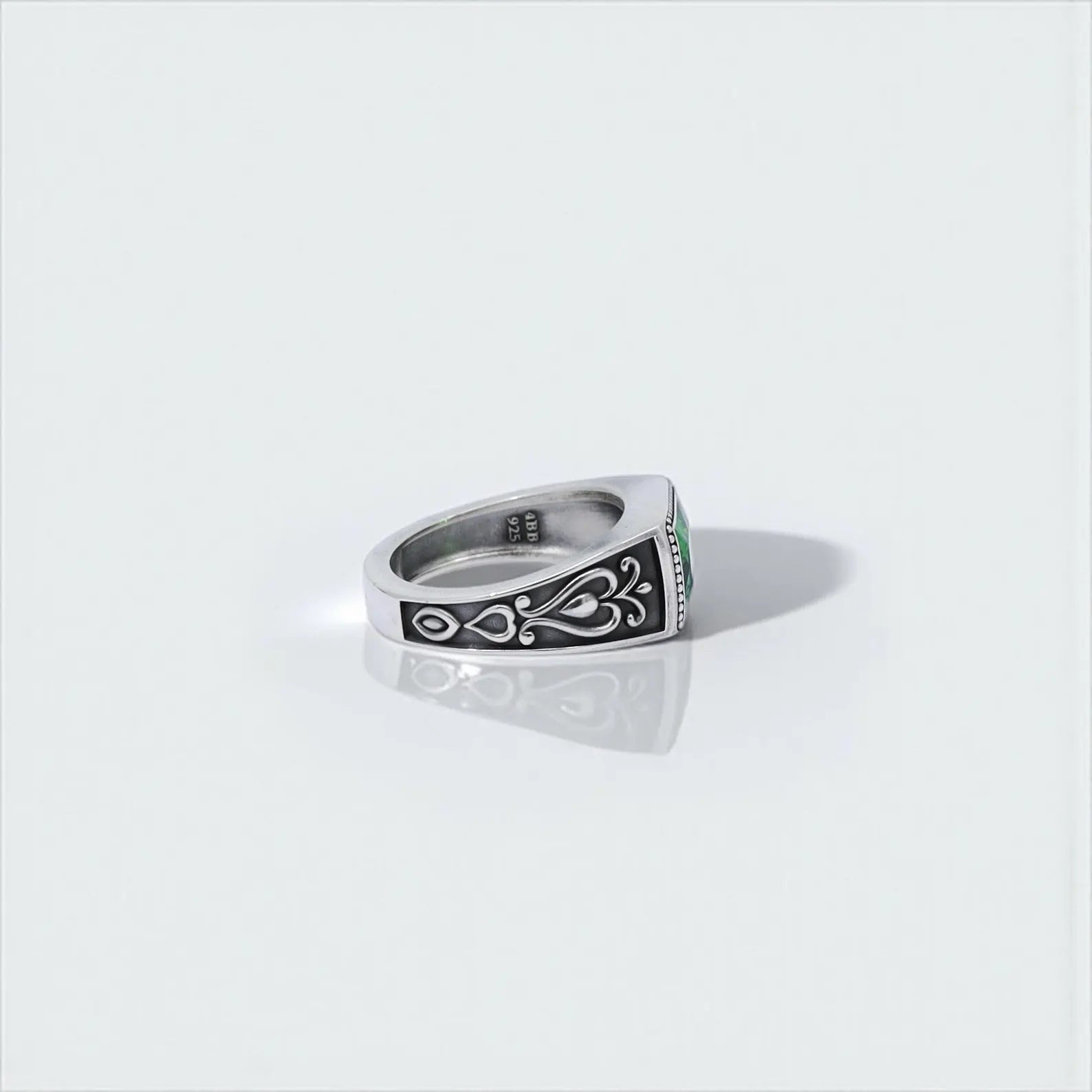 Emerald green statement ring for men with a solid silver band and gothic ornamental carvings. The square-cut gemstone symbolizes growth and power, while the handmade antique finish gives it a timeless character. A perfect gift for birthdays, anniversaries, or self-expression.