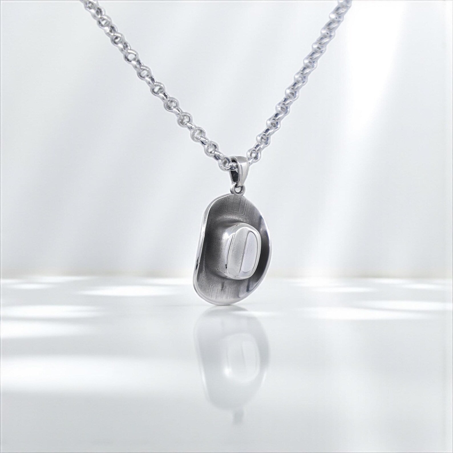 Masculine and stylish cowboy hat necklace for men, made of high-quality sterling silver with a smooth matte finish, offering a perfect blend of country pride and handmade jewelry craftsmanship.