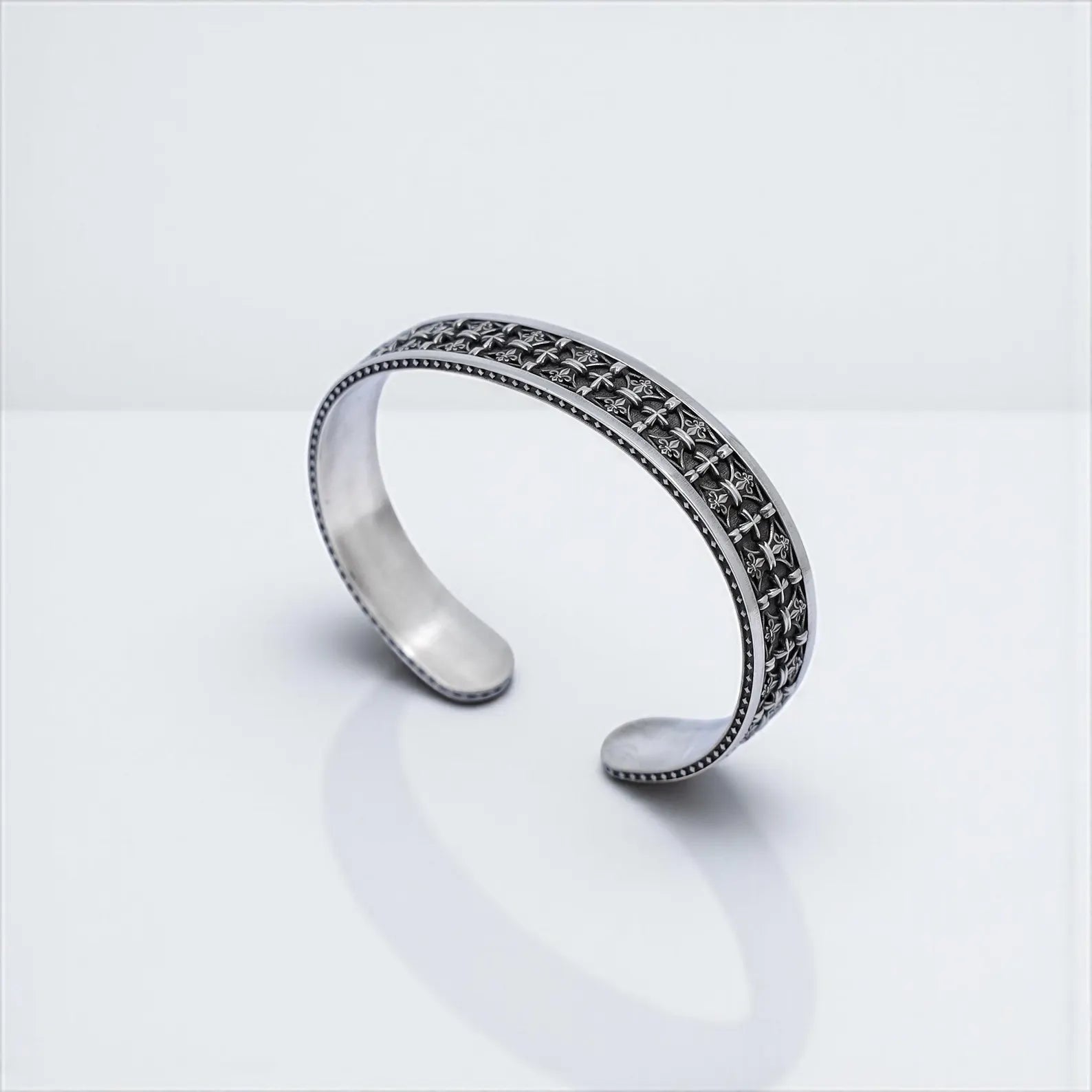 A handcrafted sterling silver cuff bracelet for men, designed with a continuous pattern of gothic cross symbols and fine detailing. This adjustable unisex piece blends traditional Christian symbolism with a bold biker aesthetic, making it a standout accessory for men who value both style and meaning. Perfect for gifting on anniversaries, birthdays, or holidays like Labor Day.