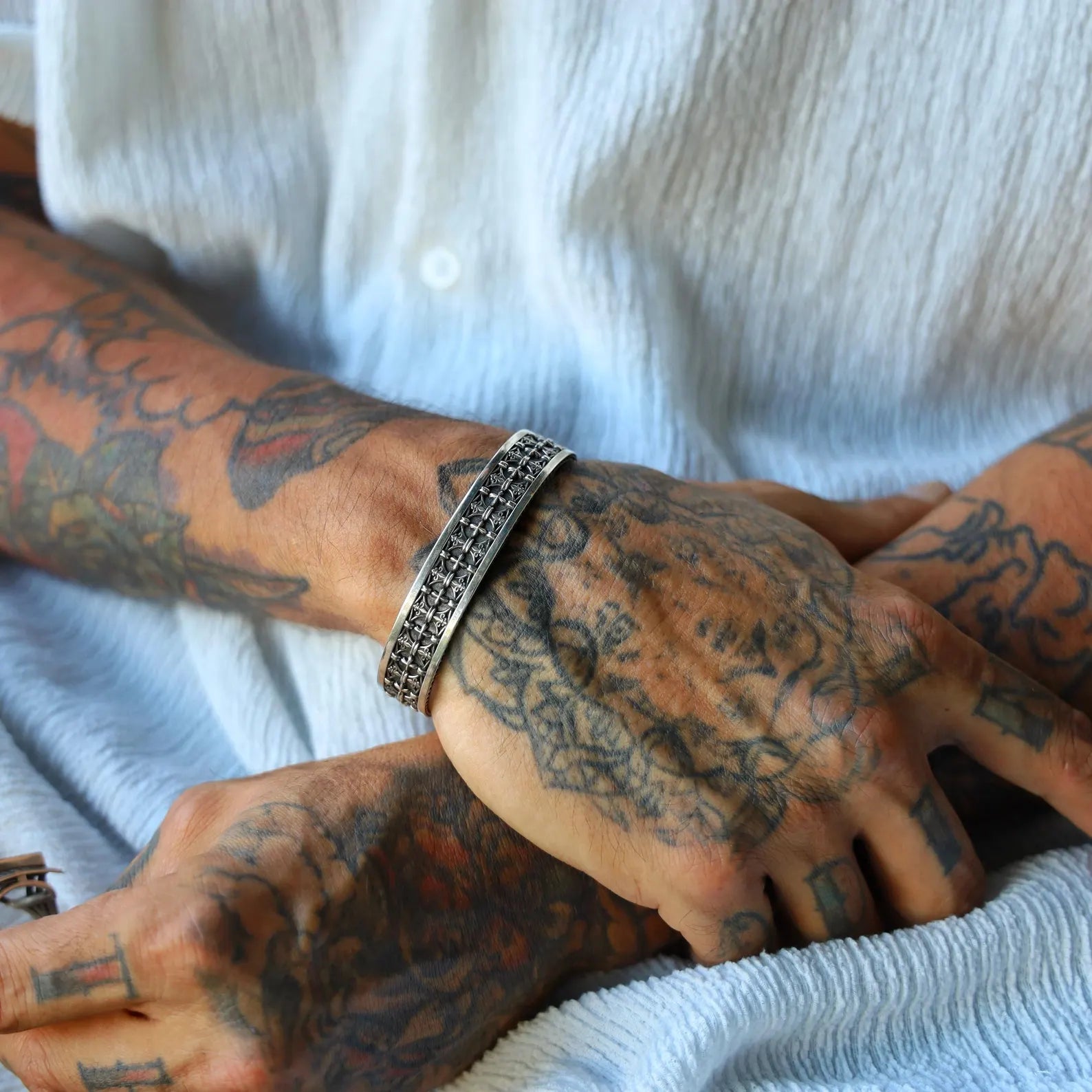 Intricately detailed men's sterling silver gothic cuff bracelet featuring repeated engraved crosses and a textured antique finish. Handmade with precision, this statement piece symbolizes strength and spirituality—ideal for those who resonate with religious symbolism and gothic fashion. Suitable as a meaningful gift for husbands, boyfriends, or sons.