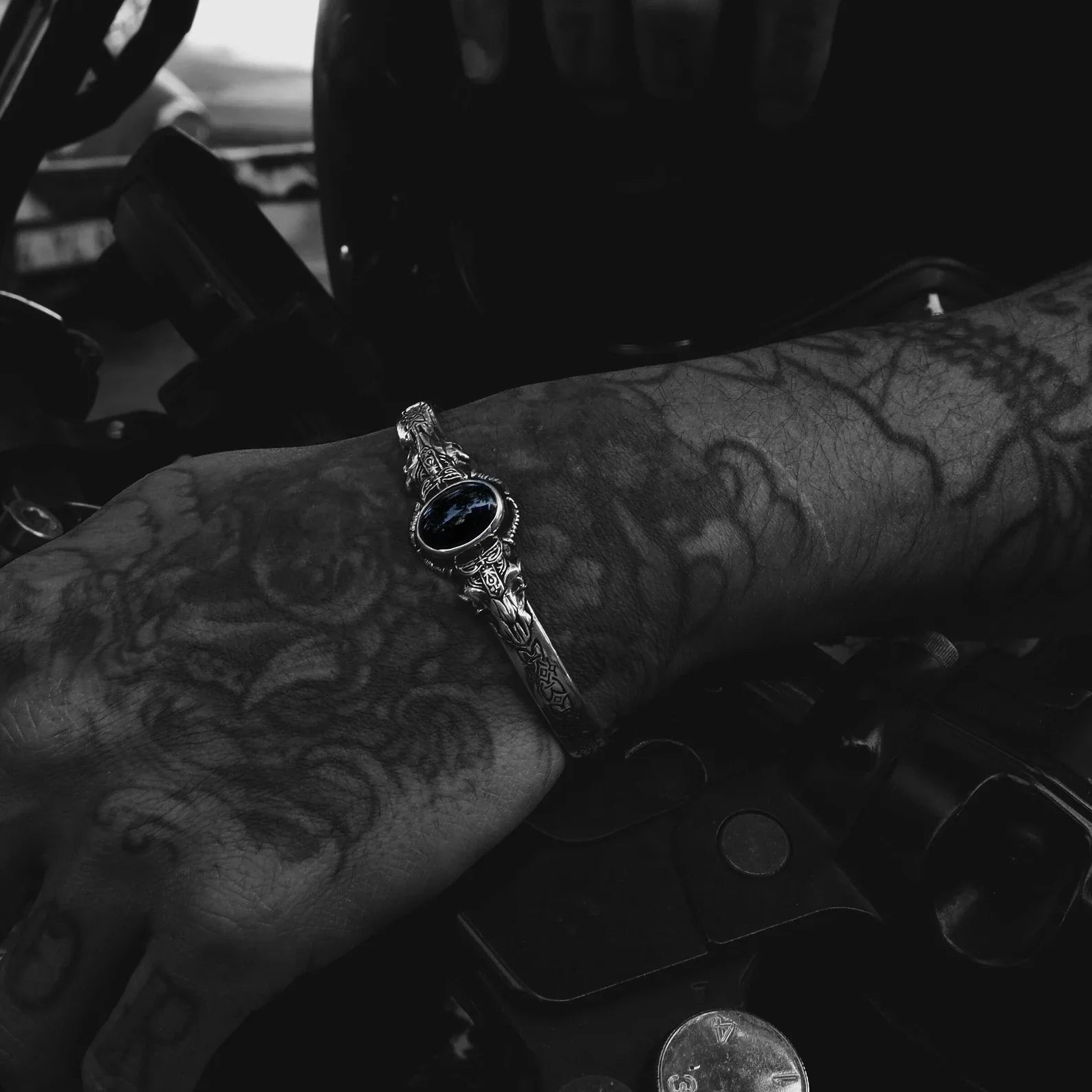 A unique sterling silver onyx bangle designed with gothic detail and medieval symbolism. The black gemstone centerpiece enhances the mystical energy of this 925K silver bracelet, making it ideal for fans of Viking culture, biker fashion, and dark fantasy aesthetics.