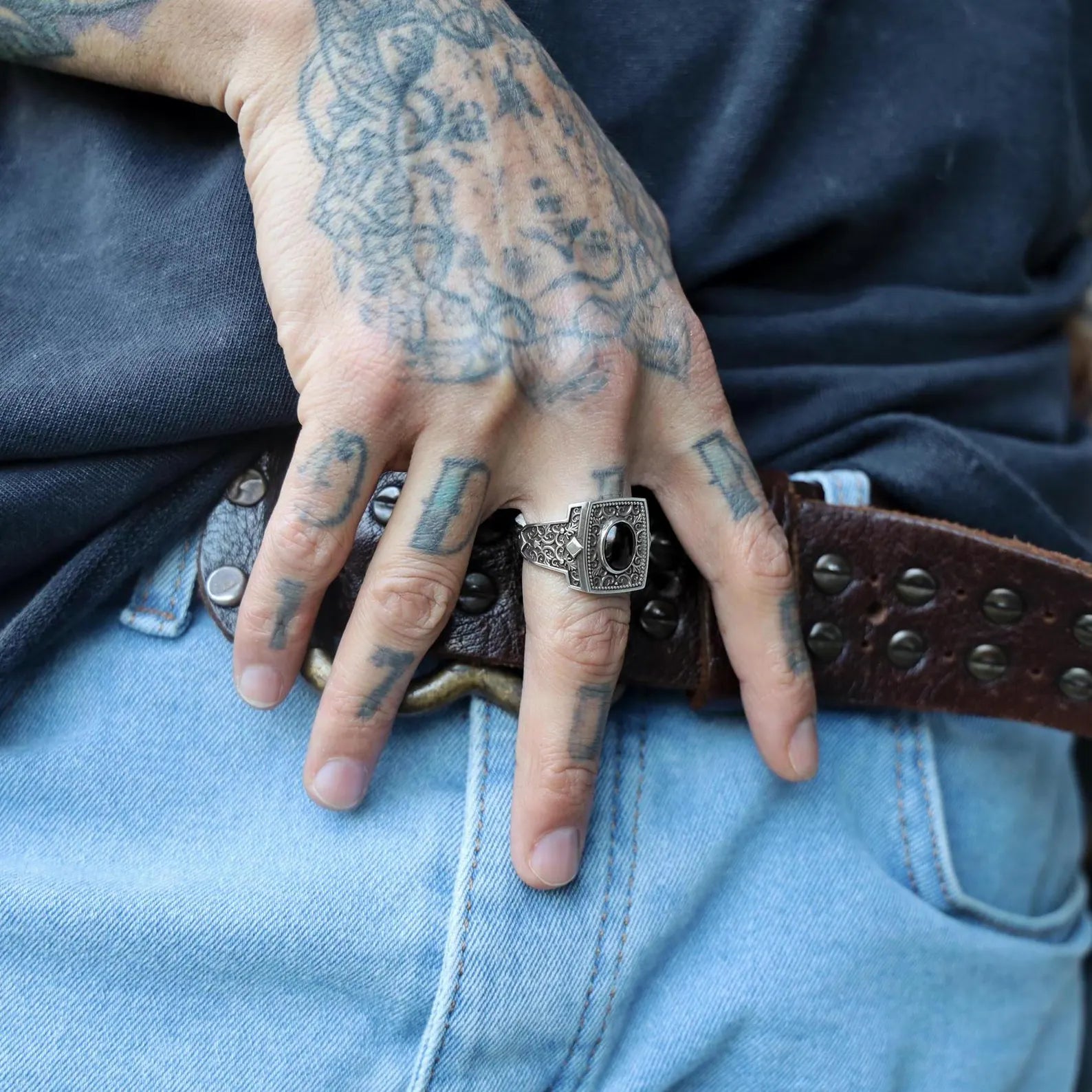 A powerful fusion of gothic elegance and bohemian soul, this sterling silver men's ring is centered with a polished black onyx gemstone, known for its grounding and protective properties. The richly textured band and antique-style oxidized finish add layers of depth and storytelling to this symbolic ring, making it a meaningful gift choice for men who embrace bold designs, handcrafted artistry, and timeless masculine style rooted in mystical symbolism.