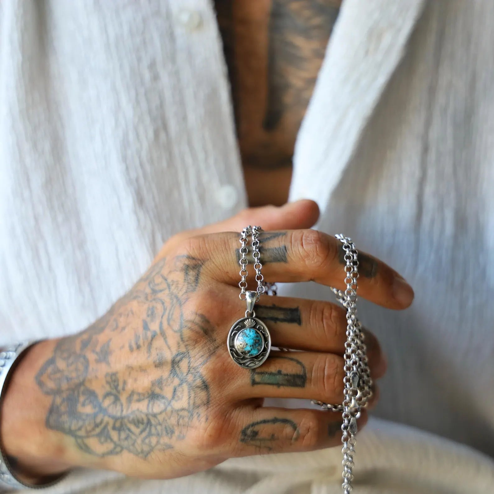 Artistic ocean-themed necklace featuring a vibrant turquoise gemstone centered in a textured silver pendant, highlighting the natural beauty of the stone and the craftsmanship of handmade jewelry.