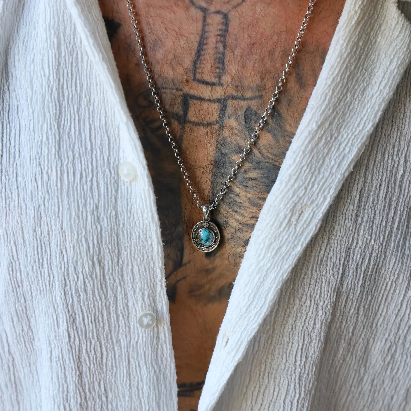 Sterling silver nautical pendant with blue turquoise gemstone, featuring finely detailed wave engravings and symbolic shell crest, perfect as a meaningful unisex gift for ocean enthusiasts or nature lovers.