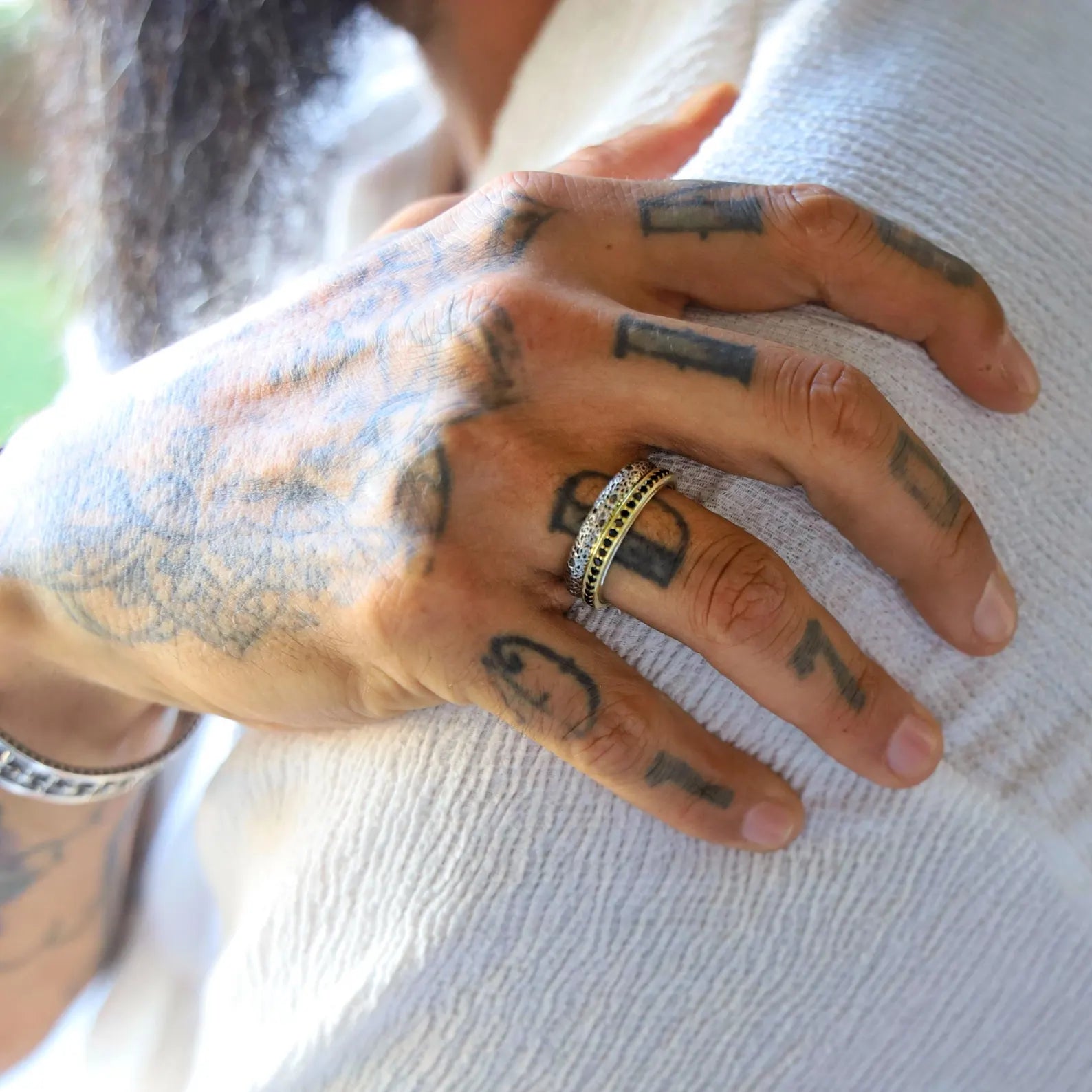 Elegant pair of handcrafted wedding bands made from 925 sterling silver and highlighted with gold plating, showcasing a rustic texture and personalized engraving, ideal for couples seeking unique, artisanal rings for their special day.