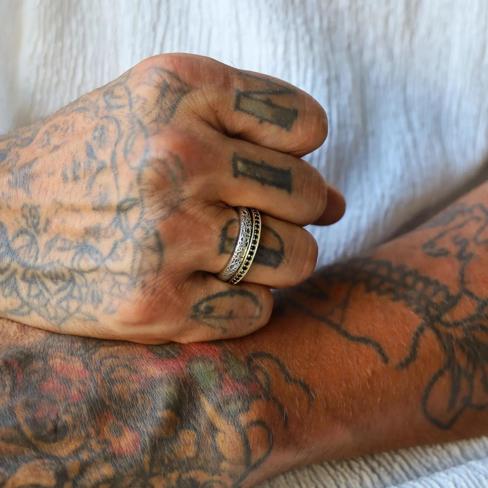 Artisan-designed matching wedding rings for him and her, made of solid silver with gold-plated detailing and customizable engravings, featuring a raw, handcrafted texture that blends tradition with modern elegance.