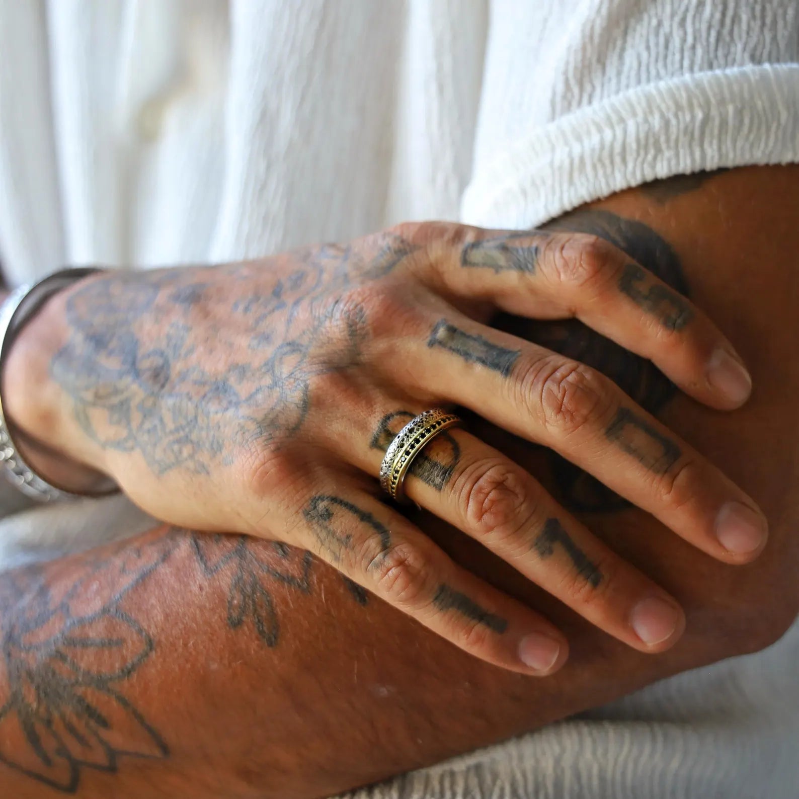 Sterling silver and gold-plated couple rings with a distinctive hammered texture, custom-engraved on the inner band, created as a handcrafted symbol of unity and perfect for weddings, anniversaries, or vow renewals.