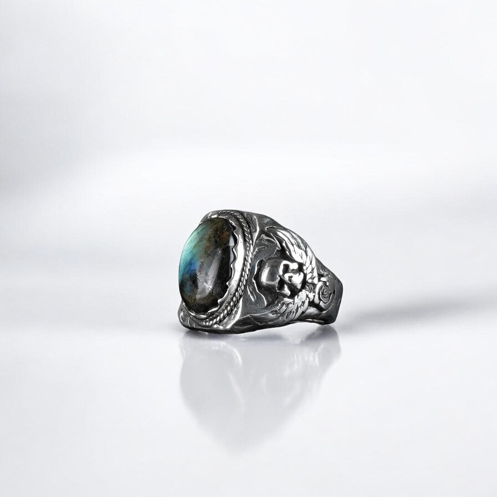 An artisan-made gothic ring forged in 925 sterling silver, set with a glowing labradorite stone and detailed skull accents. The ring merges spirituality with rugged edge, creating a powerful piece that reflects strength, mystique, and fearless self-expression.