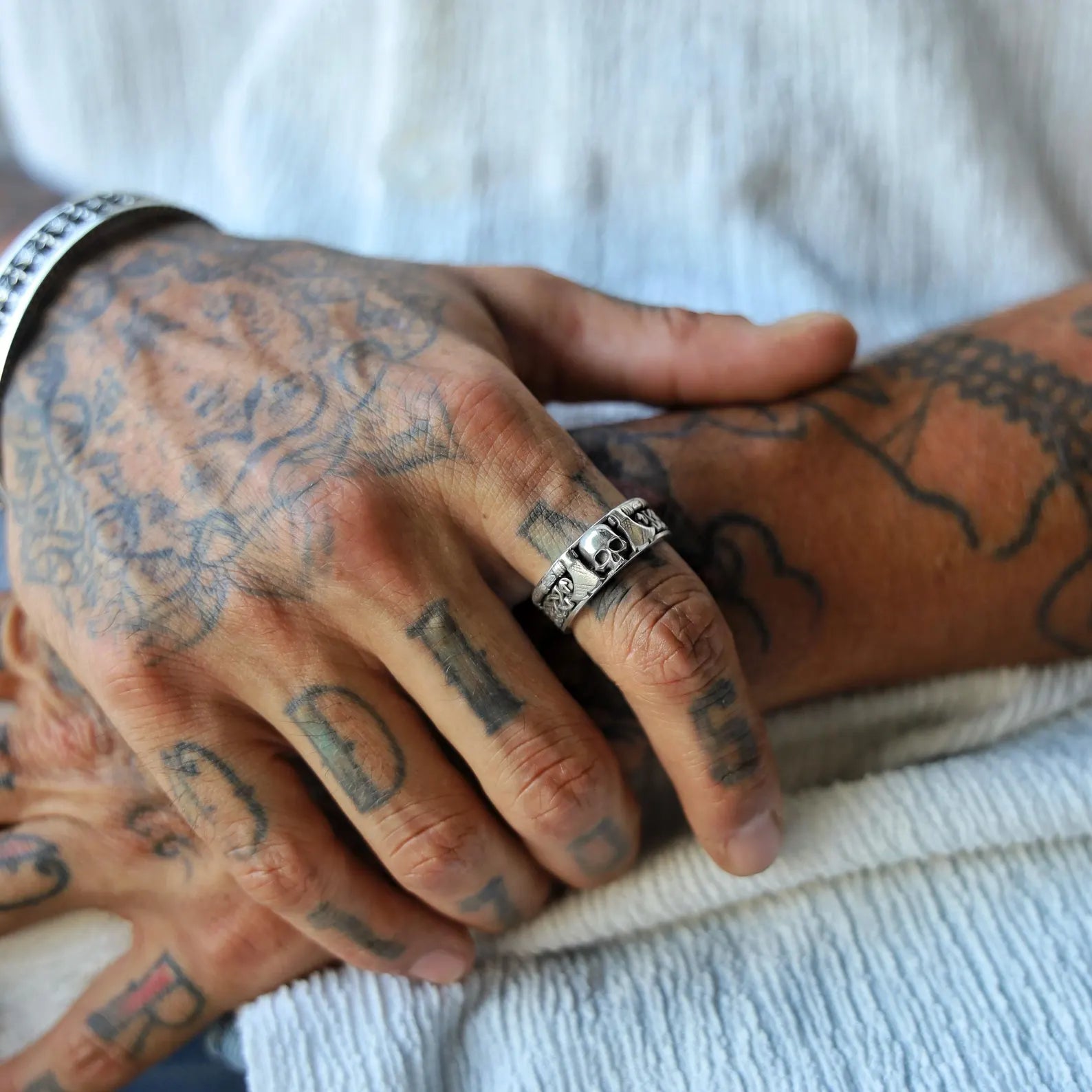 Close-up shot of a handmade Norse warrior ring for men, showcasing a detailed skull centerpiece surrounded by Viking axe and knotwork patterns. Crafted from genuine sterling silver, this band is perfect for gothic, biker, or medieval-style lovers. A powerful statement ring that captures the essence of Nordic heritage and ancient warrior culture.