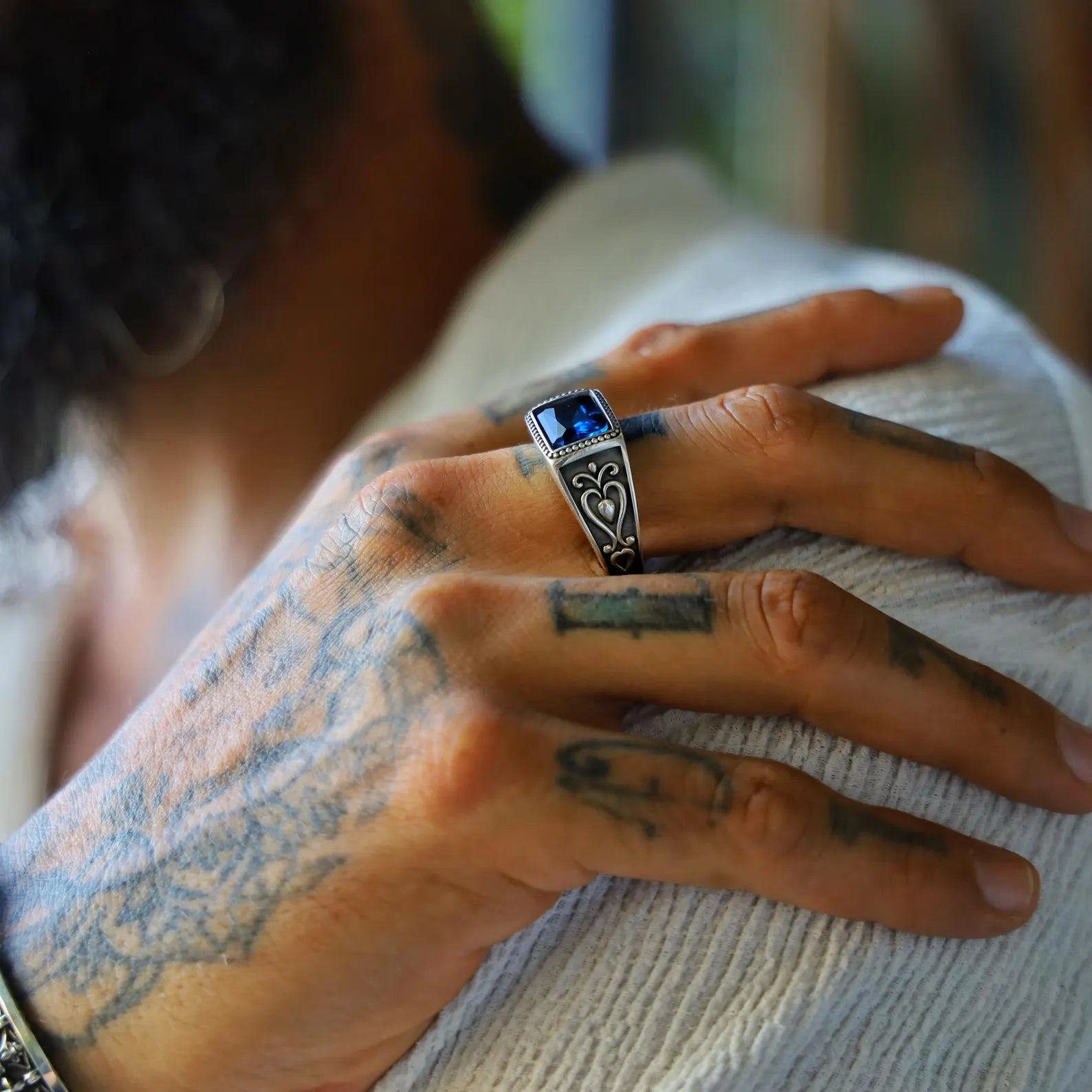 High-resolution photo of a sapphire-inspired blue gemstone ring for men, handmade in solid 925 sterling silver with intricate oxidized accents and a powerful masculine look.