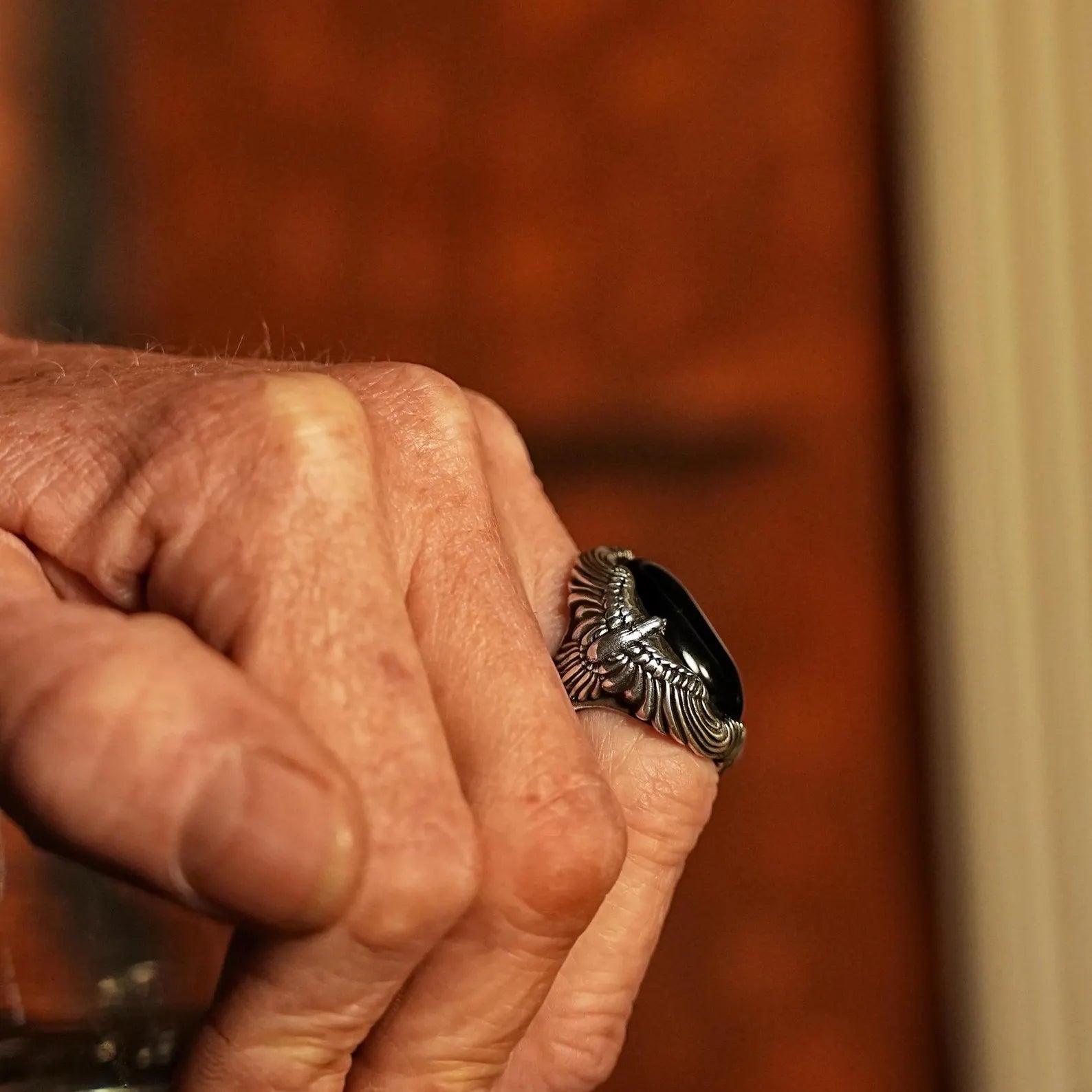 A solid and heavy onyx ring forged in 925 sterling silver, styled with sculptural eagle wing textures and a bold oval black gemstone. This piece embodies biker style, mythological depth, and meaningful personalization options through engraving.