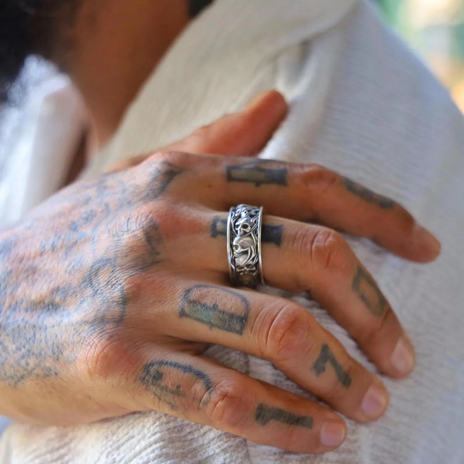 Oxidized sterling silver skull ring for men with intricate gothic engravings across the entire band. The handmade detailing highlights a rebellious, fearless spirit that reflects biker lifestyle and ancient death symbolism. A bold and expressive accessory for those who seek powerful, unique statement pieces.