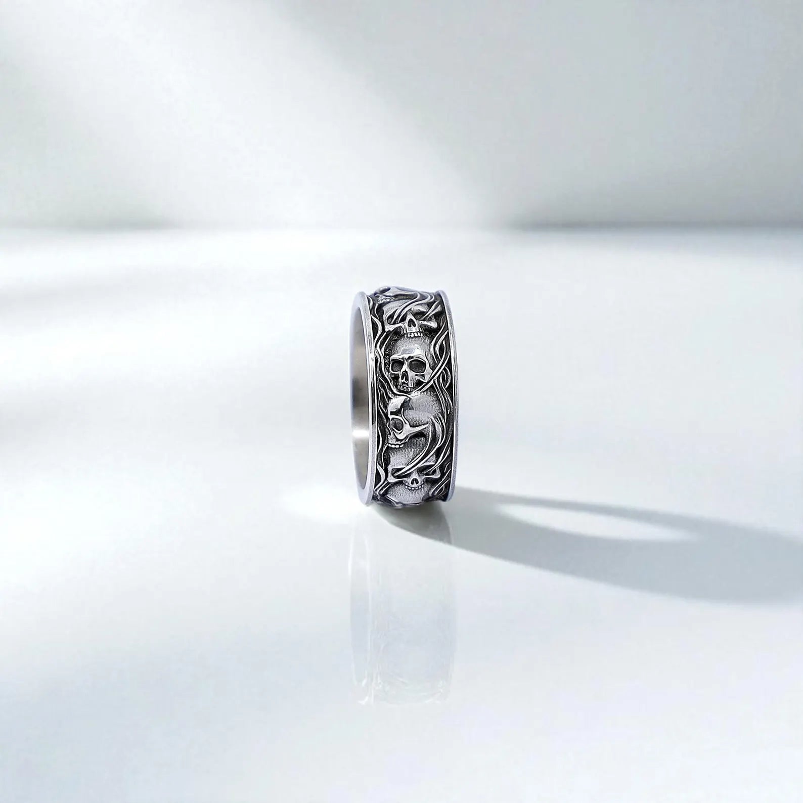 Masculine sterling silver ring with prominent skull engravings inspired by gothic and biker culture. Each skull is carved by hand into a wide silver band with oxidized shadows that enhance the dramatic look. Ideal for everyday wear or as a symbolic ring representing inner strength, mortality, and bold individuality.