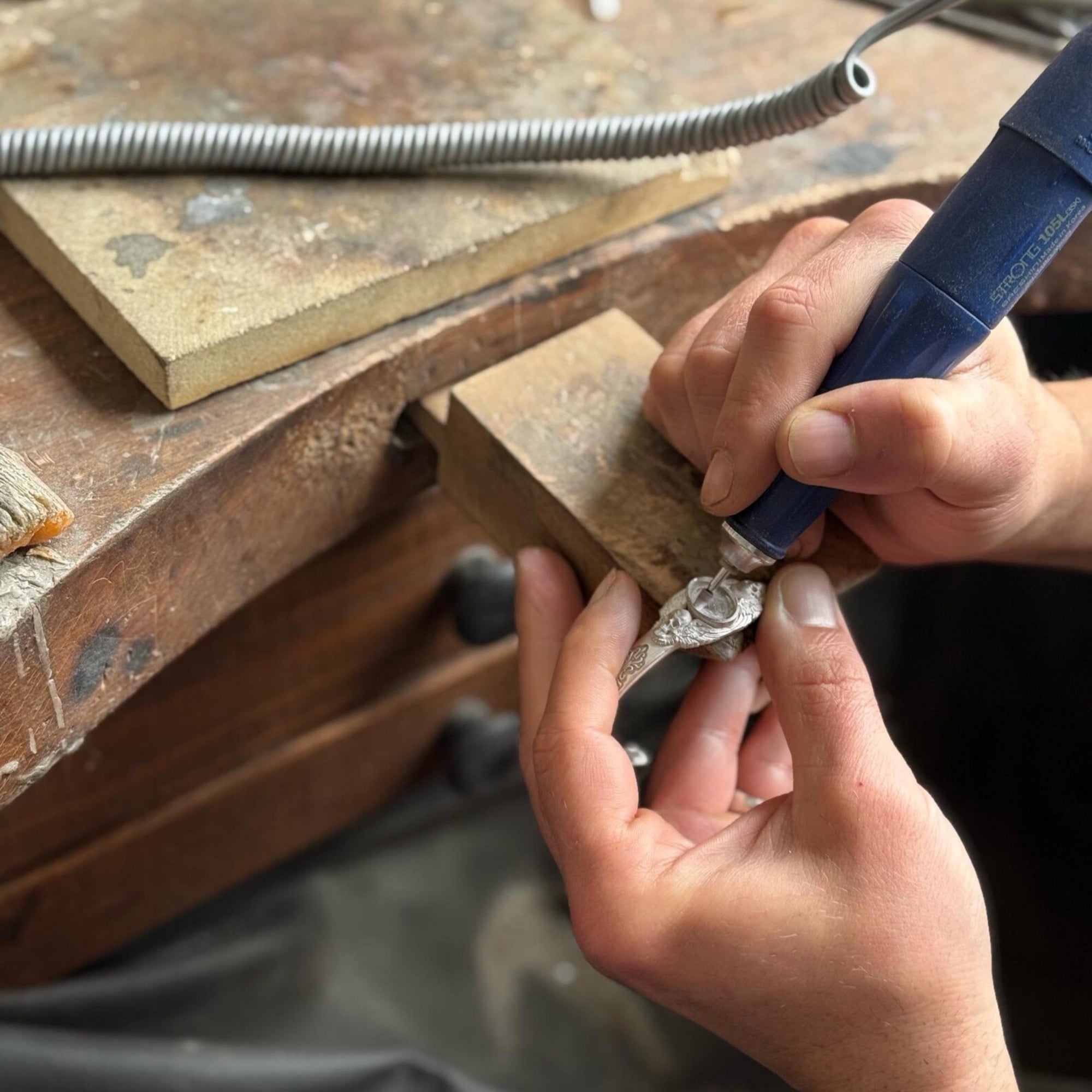 Minimal background image of a handmade silver cuff bracelet featuring a natural black onyx gemstone and twin skulls. Perfectly polished with deep oxidation for contrast — an authentic piece of gothic luxury jewelry.