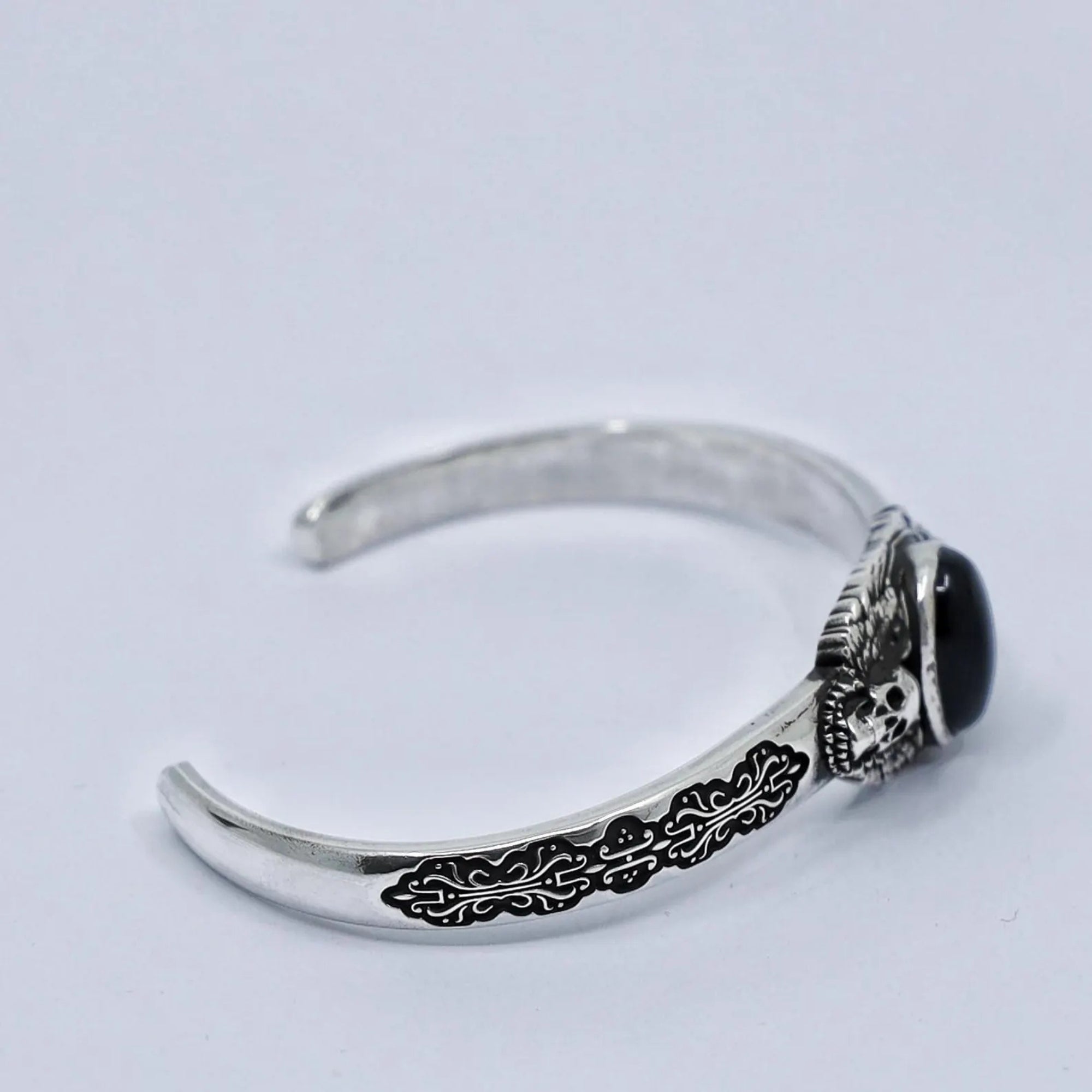 Premium handcrafted black onyx skull cuff bracelet made of solid 925 sterling silver. The deep onyx gemstone symbolizes inner strength and protection, while the twin skull engravings add a gothic flair. Perfect for men who appreciate artisan craftsmanship and unique handmade silver jewelr