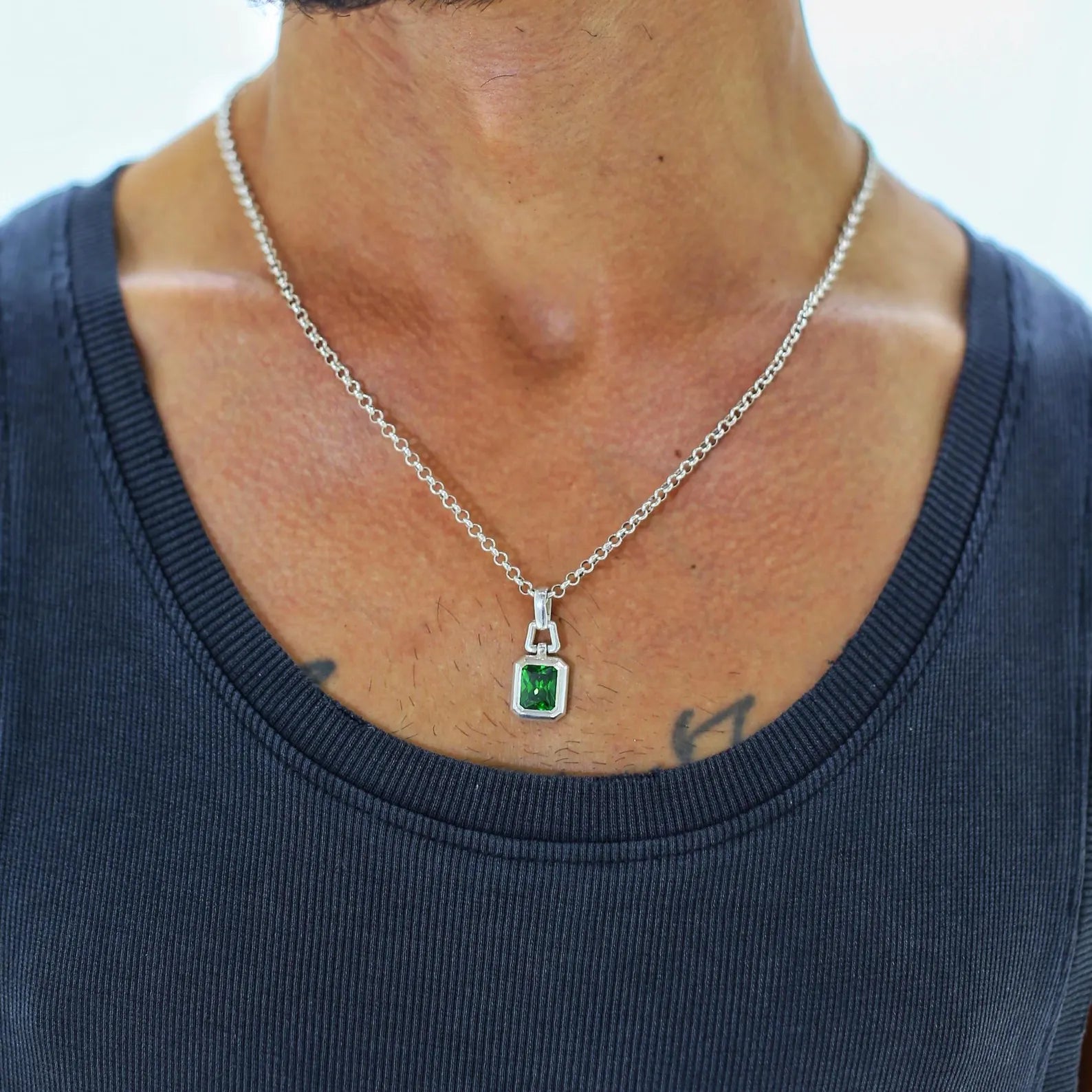 A meticulously crafted green gemstone pendant necklace made with solid sterling silver and detailed with an emerald-cut zircon stone, symbolizing clarity, growth, and wisdom. Designed to be unisex, this minimalist yet eye-catching necklace brings together modern design and traditional elegance. A meaningful jewelry piece for men or women who appreciate fine craftsmanship and personal expression.