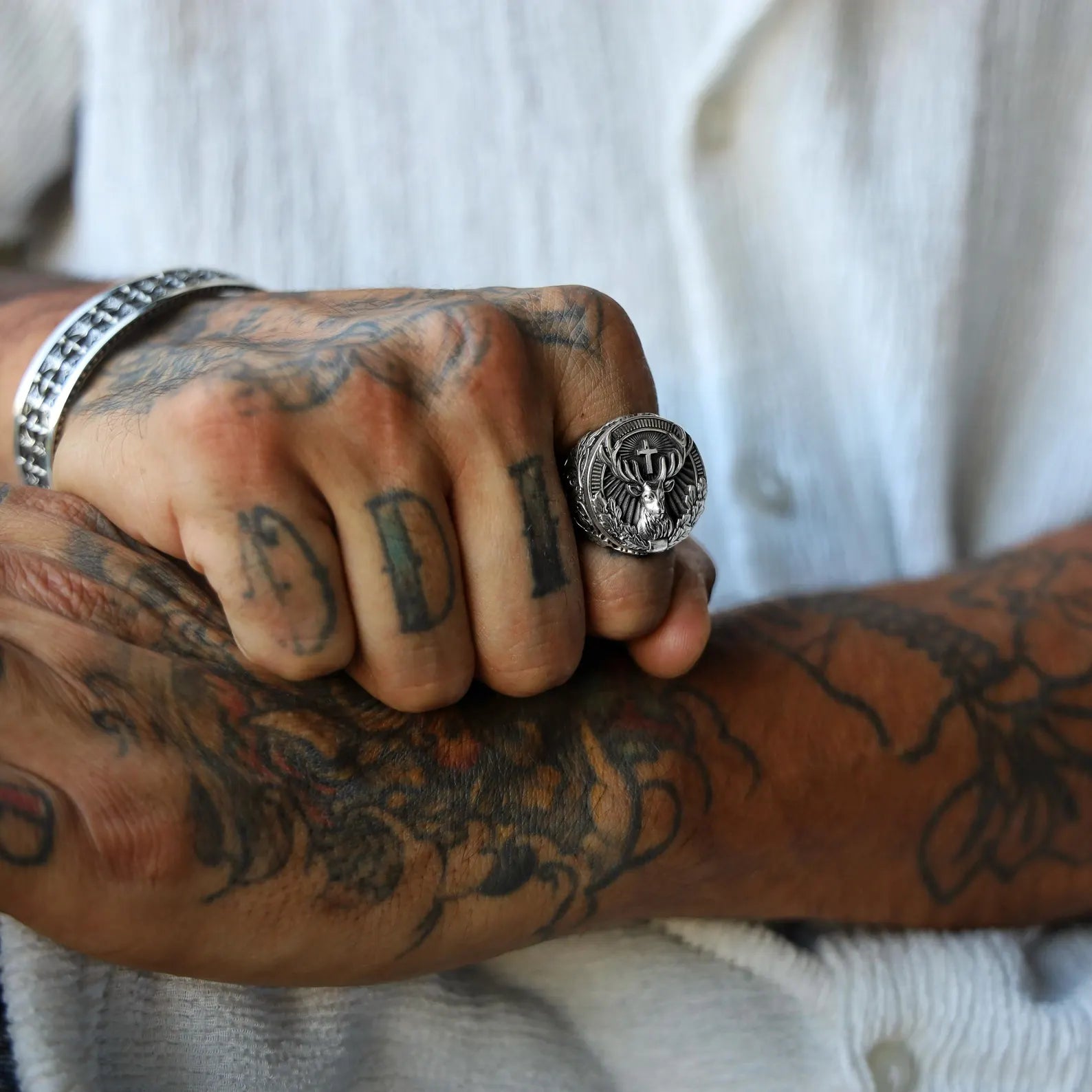 Sterling silver men’s ring with a bold deer motif and gothic leaf detailing, handcrafted to reflect a deep connection to the wilderness, spirituality, and forest-inspired jewelry design.