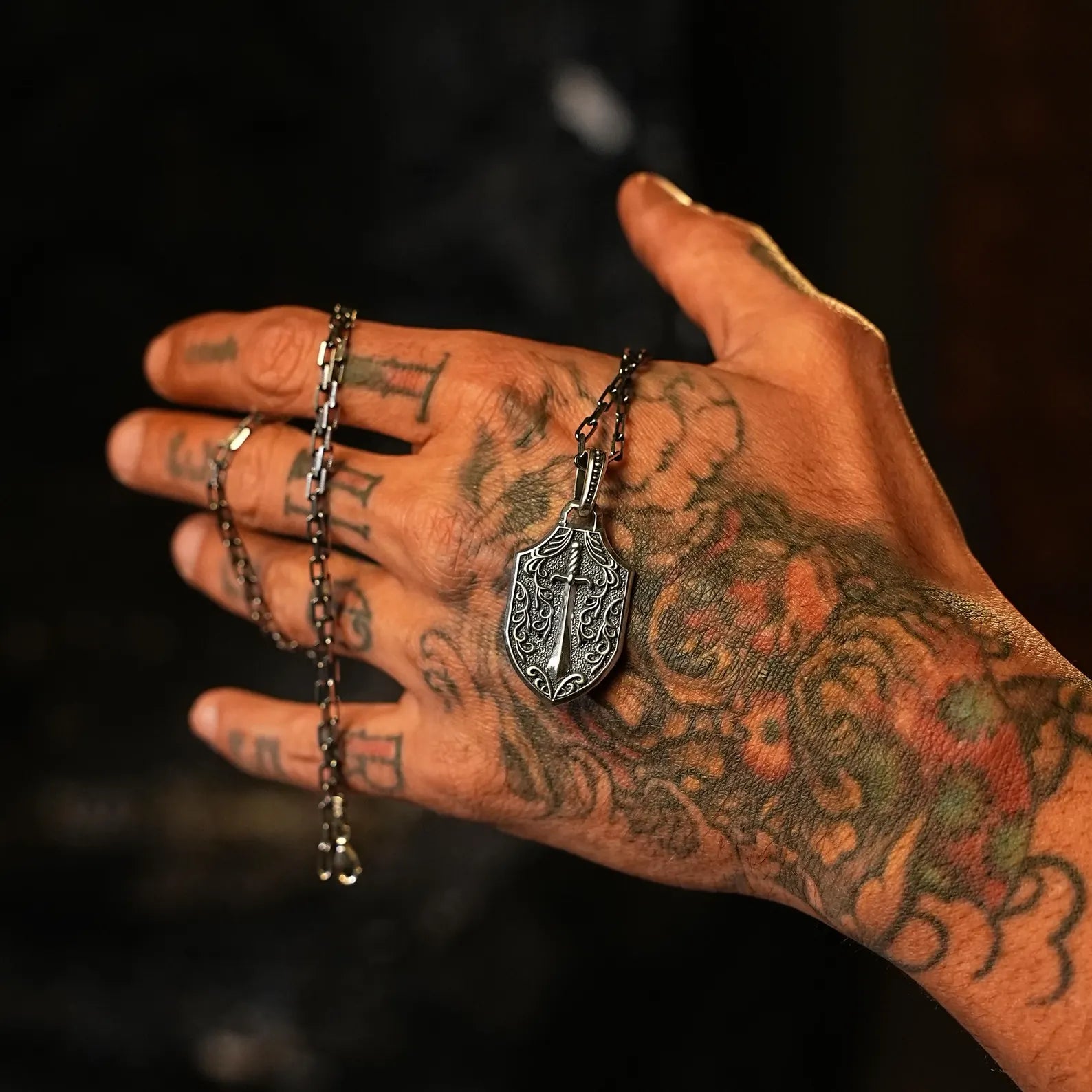 Intricately designed silver skull necklace with sword engraving on the back, made for those who seek symbolic and powerful jewelry. This gothic shield pendant is handcrafted for maximum impact and makes a unique birthday or anniversary gift for skull enthusiasts, bikers, and punk style fans.